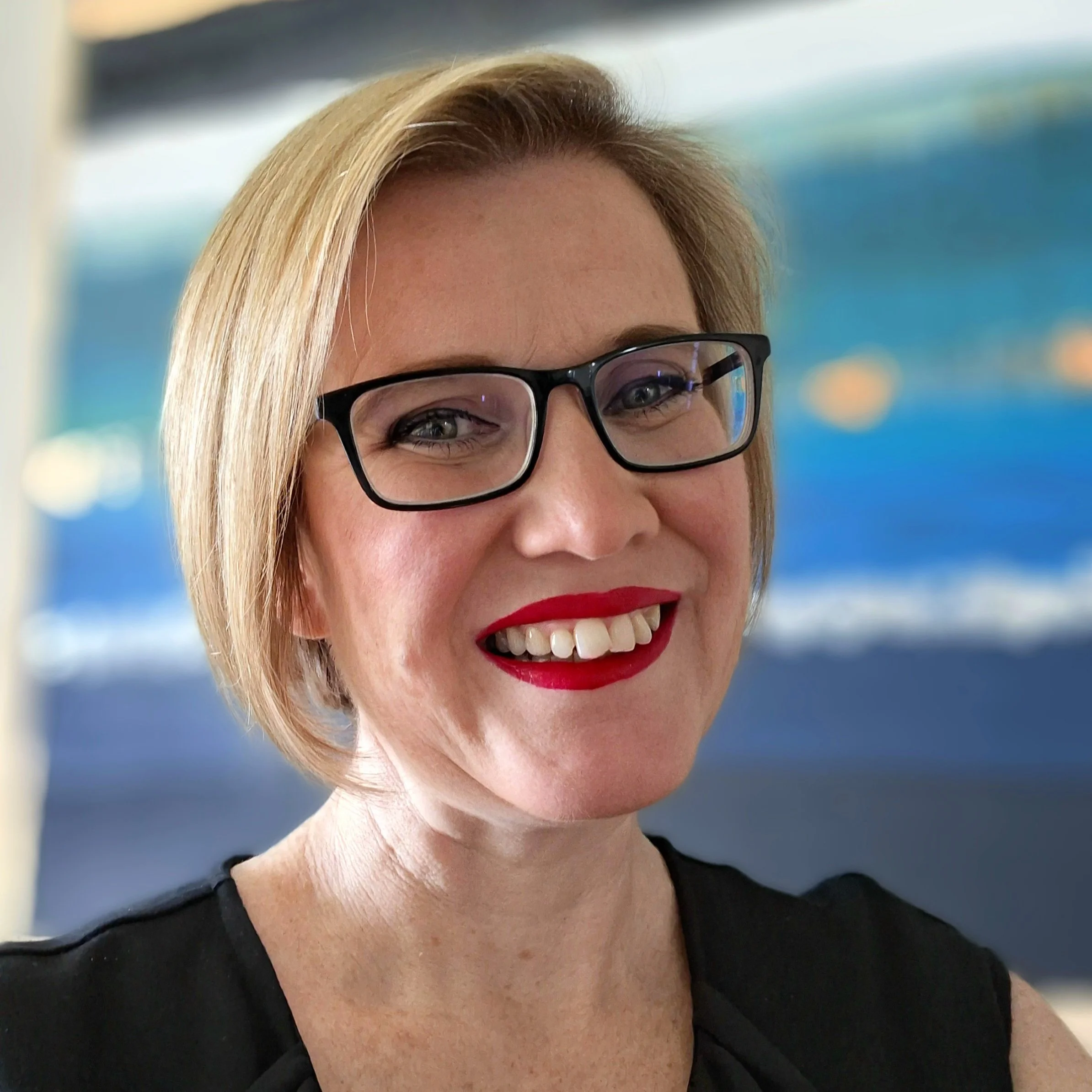 A woman smiling with a blue backgroun