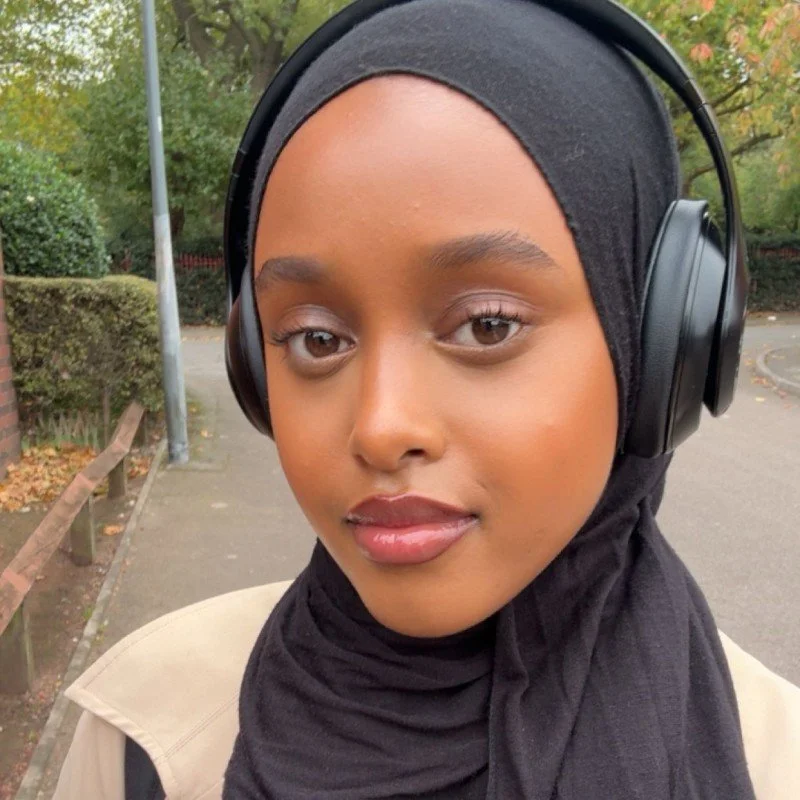 A girl wearing a hijab with headphones