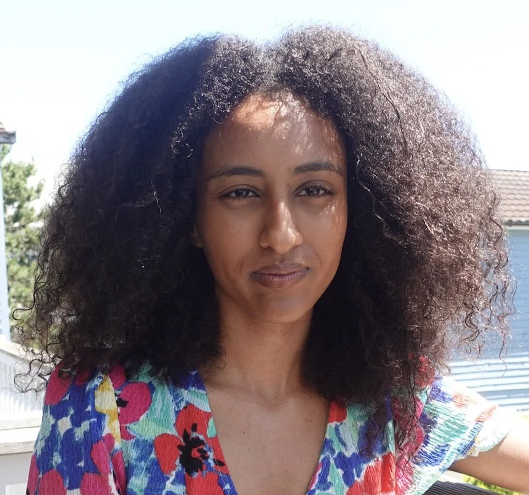 A mixed-race woman with curly hair