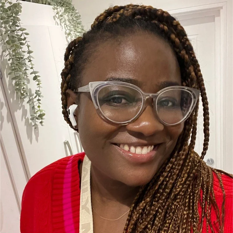 A black woman with braids smiling