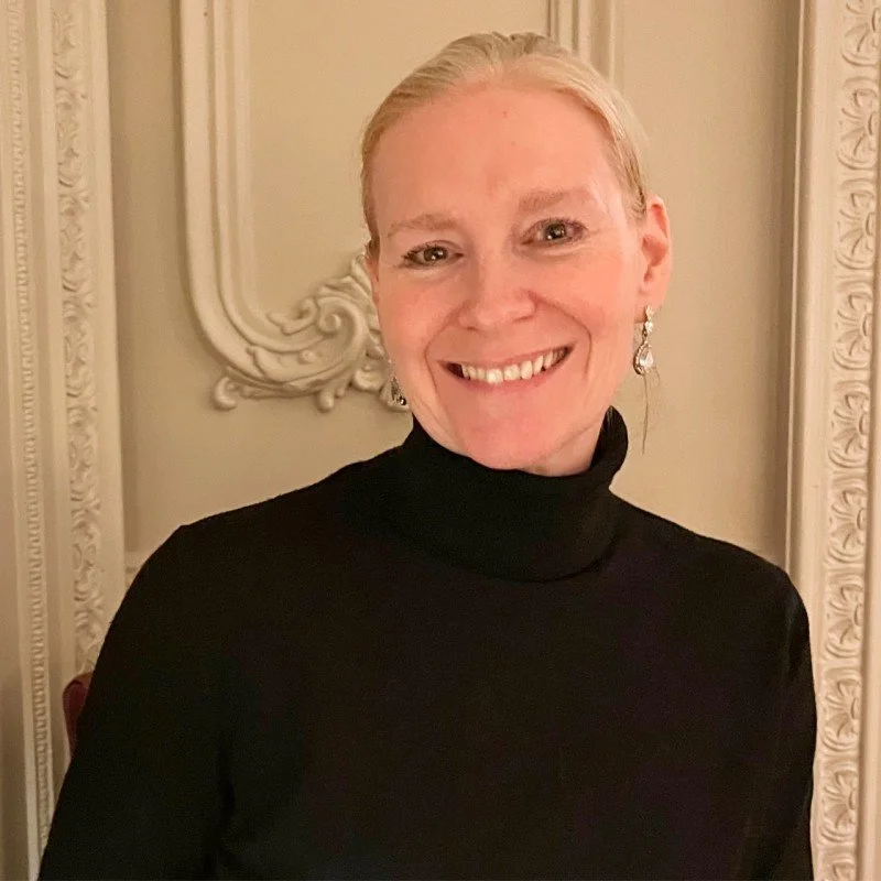 A woman wearing black, smiling