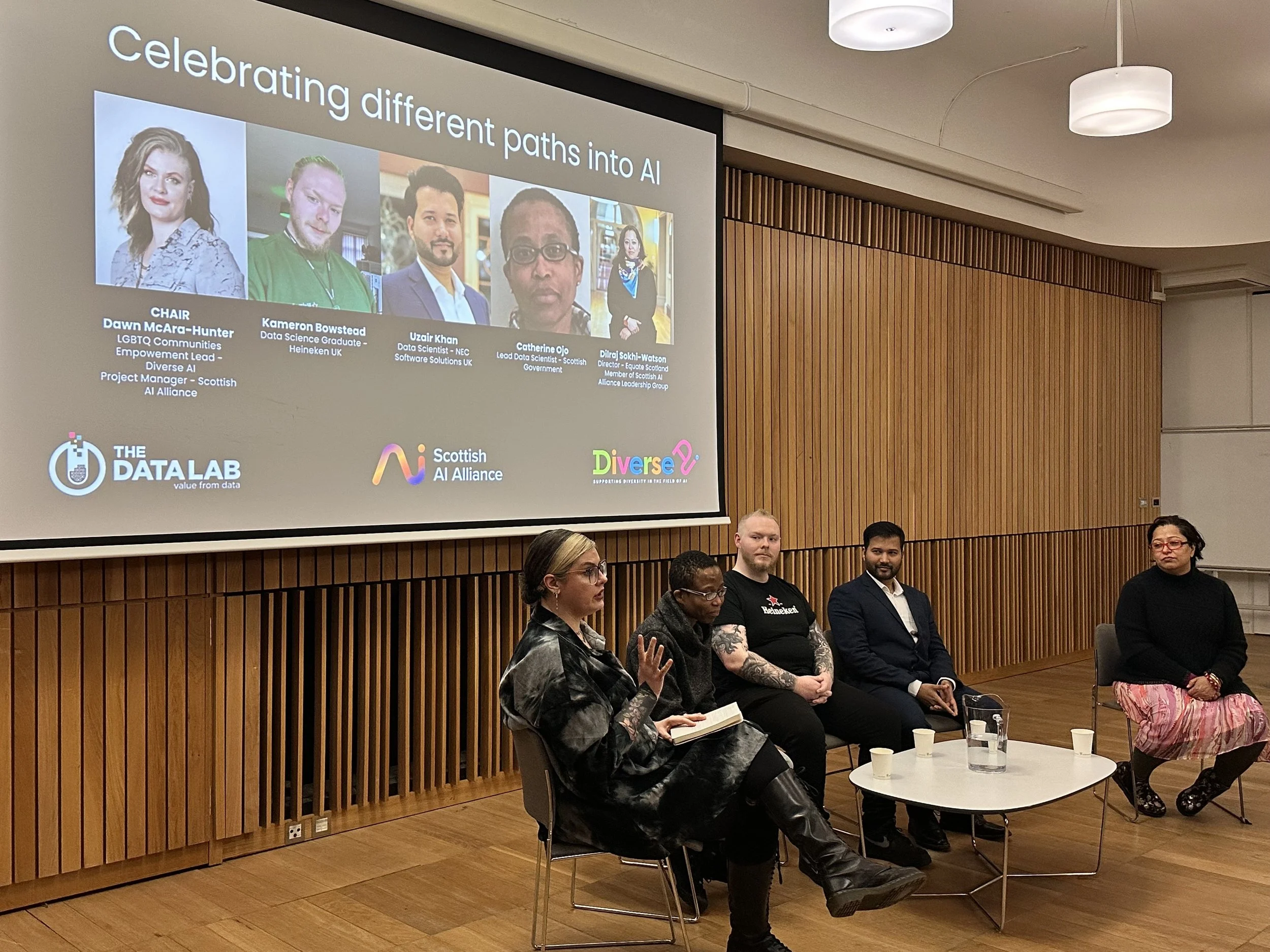 3 women and a man sitting down and talking 