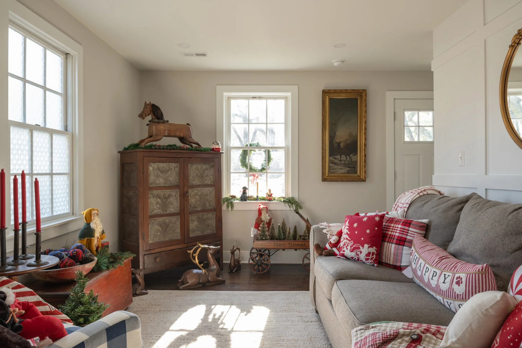 A cozy living room decorated with Christmas decorations, including a small Christmas tree, holiday pillows, and vintage ornaments.