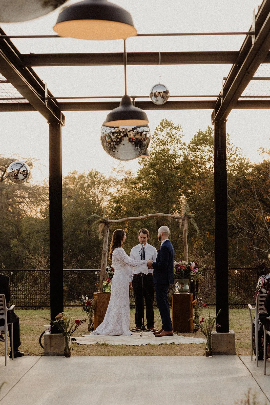 A wedding ceremony on the covered patio at Duetts, with disco balls overhead.