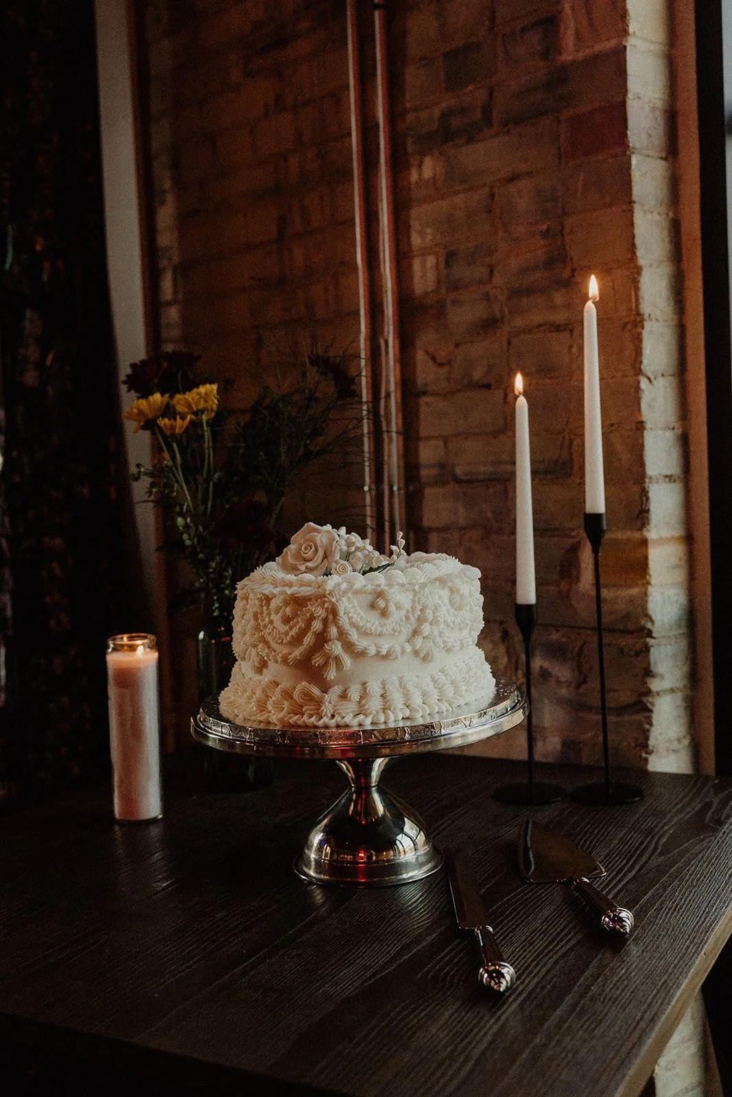 A wedding cake displayed with candles at Duetts Texas Club.