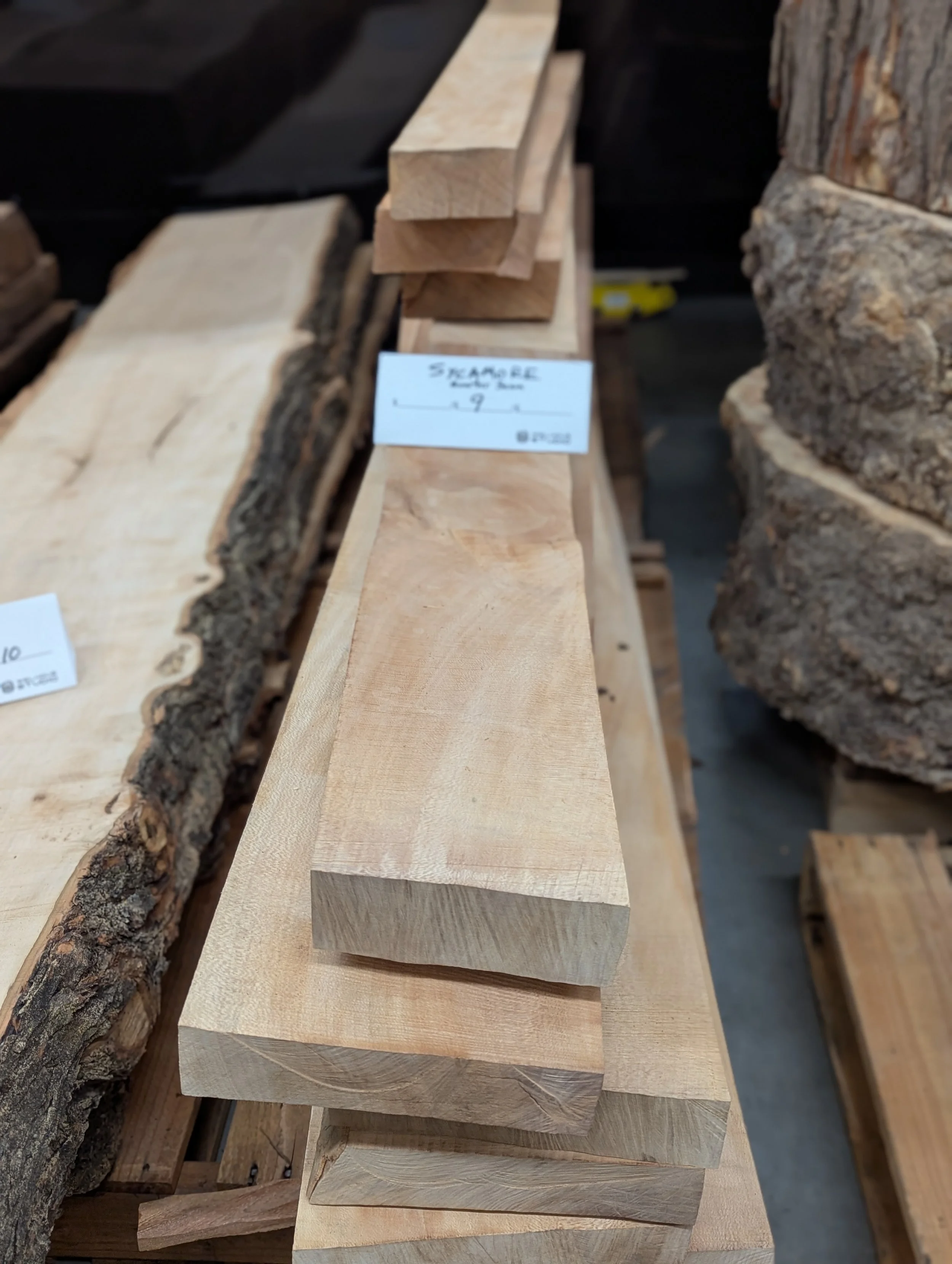 Stacked pieces of cut lumber on a shelf at a store or warehouse.