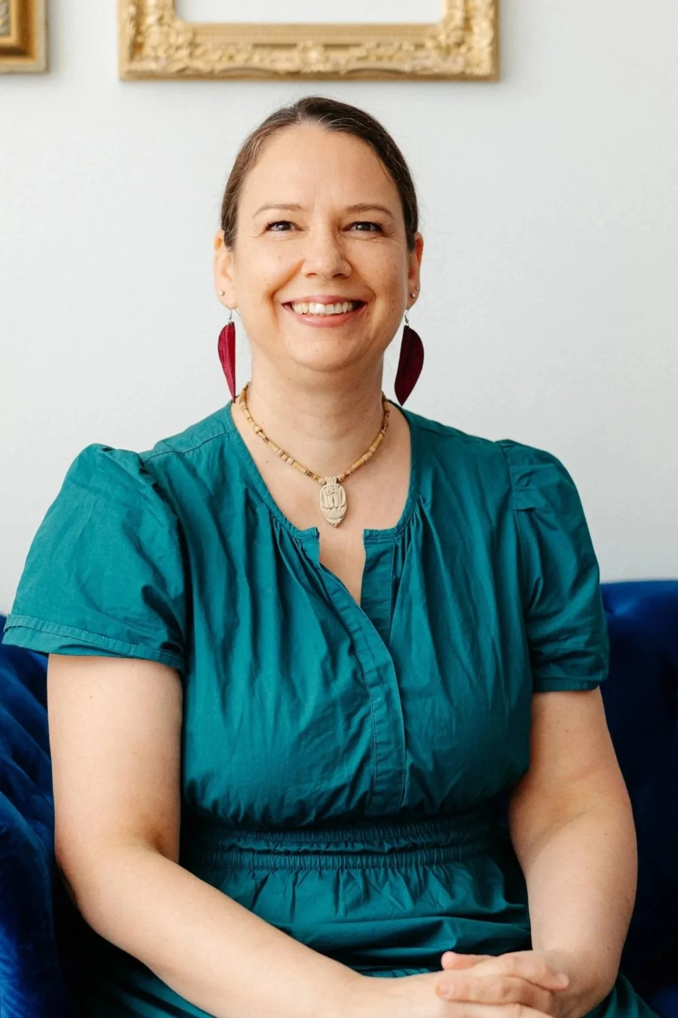 Woman wearing a blue dress while wearing red earrings