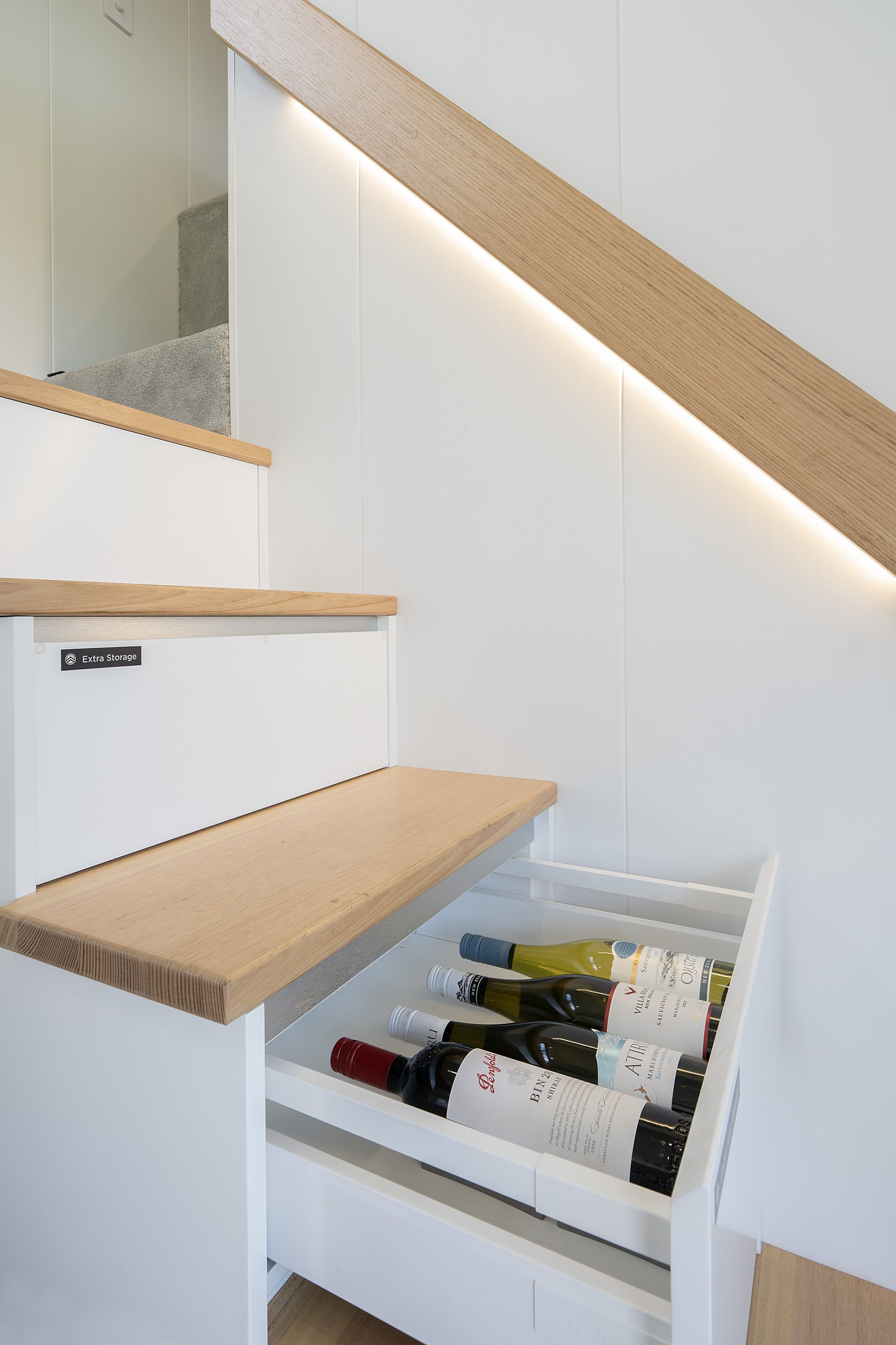 Staircase with integrated drawer storage containing wine bottles