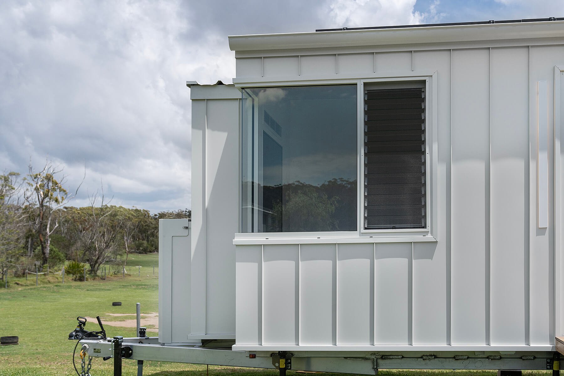 Partial view of a white tiny house, wanda tiny solar home, tiny house, eco home, caravan, down sizing, small home