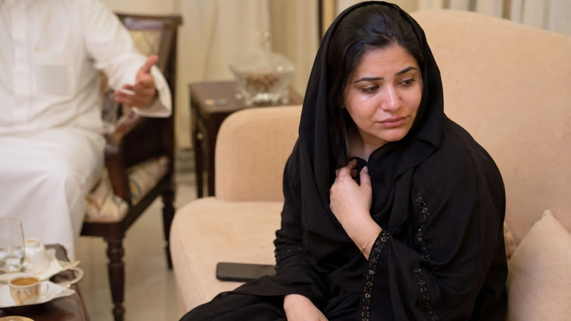 Gulf Arab woman looking hurt after an emotional conversation, showing “kasart khaatri” as feeling disappointed or heartbroken.