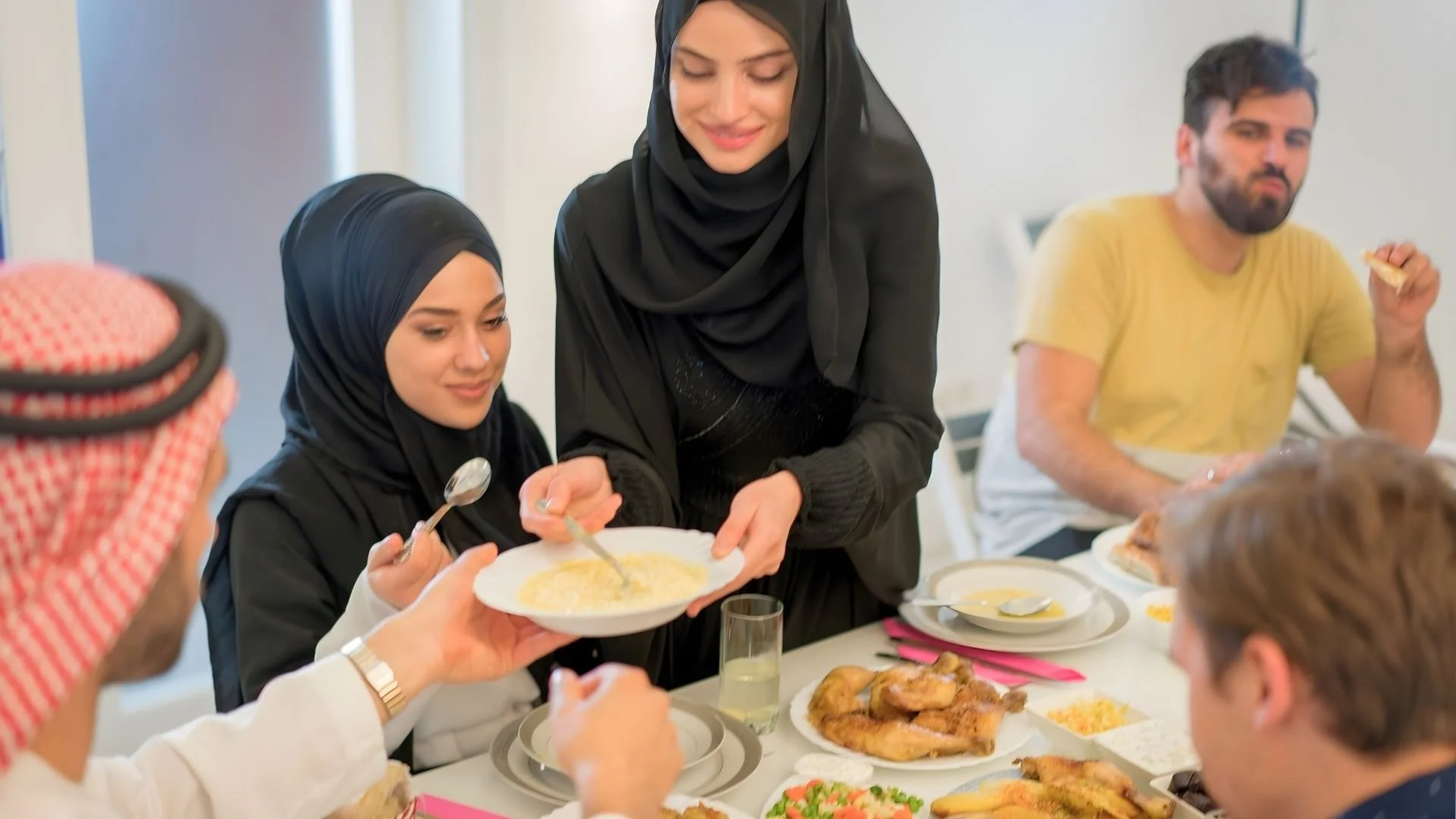 Arab and non-Arab guests sharing iftar, reflecting Ramadan hospitality and community spirit