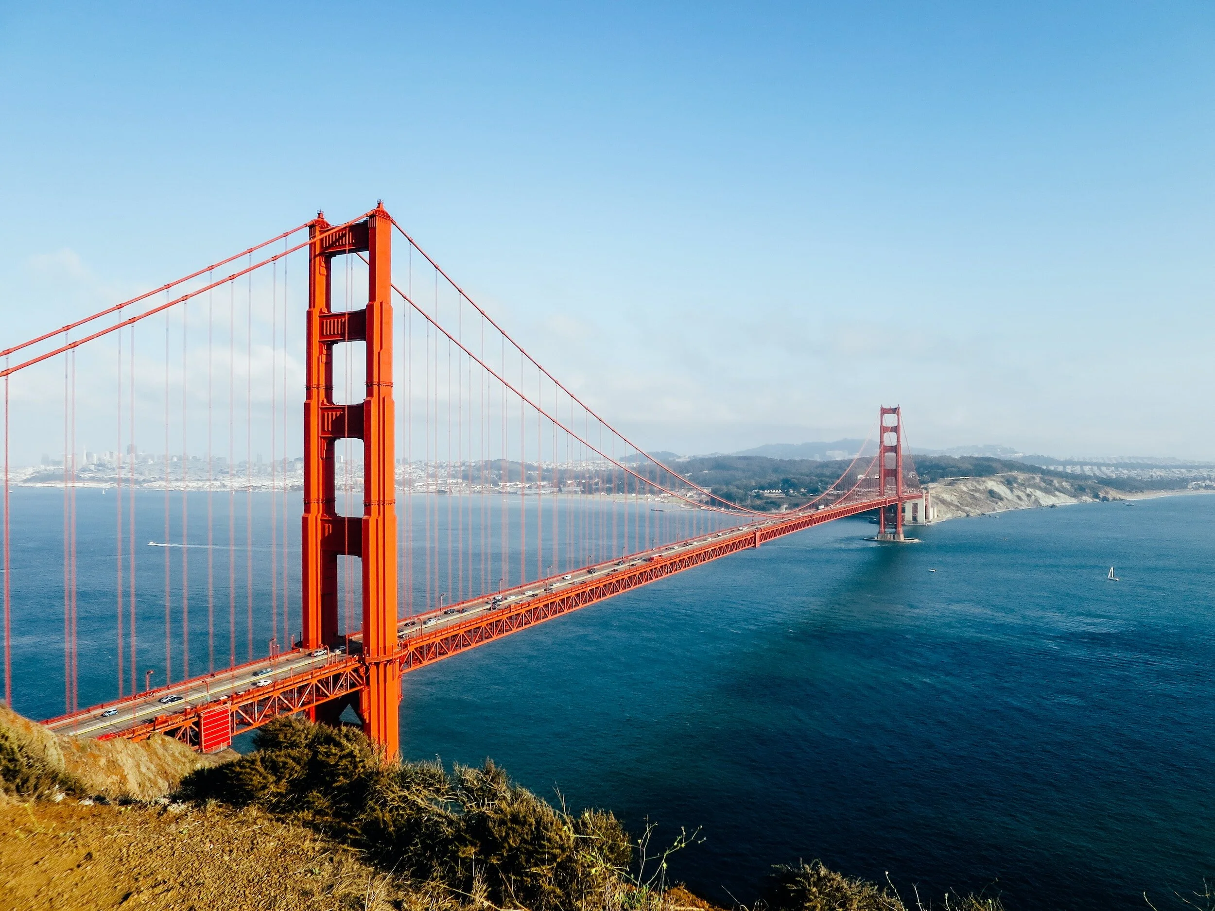 Golden Gate Bridge spanning the water with cityscape in the background