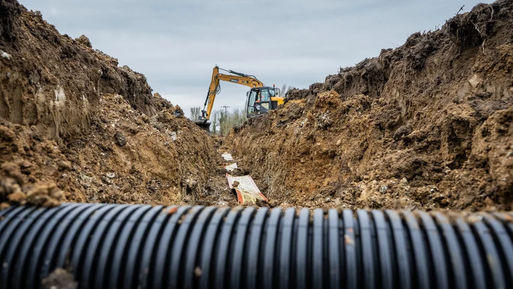 Excavator digging a drainage trench