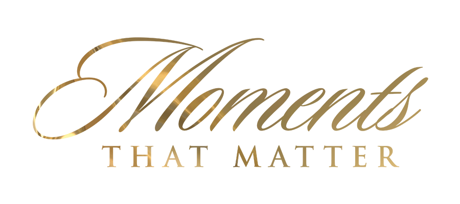 Close-up of a gold-colored key with the word 'CHANEL' engraved, lying on a reflective surface.