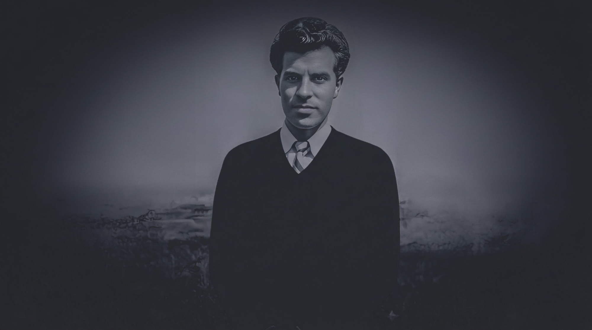 A black and white portrait of a man in a suit with a striped tie, standing in front of a landscape background with cloudy sky and distant mountains.
