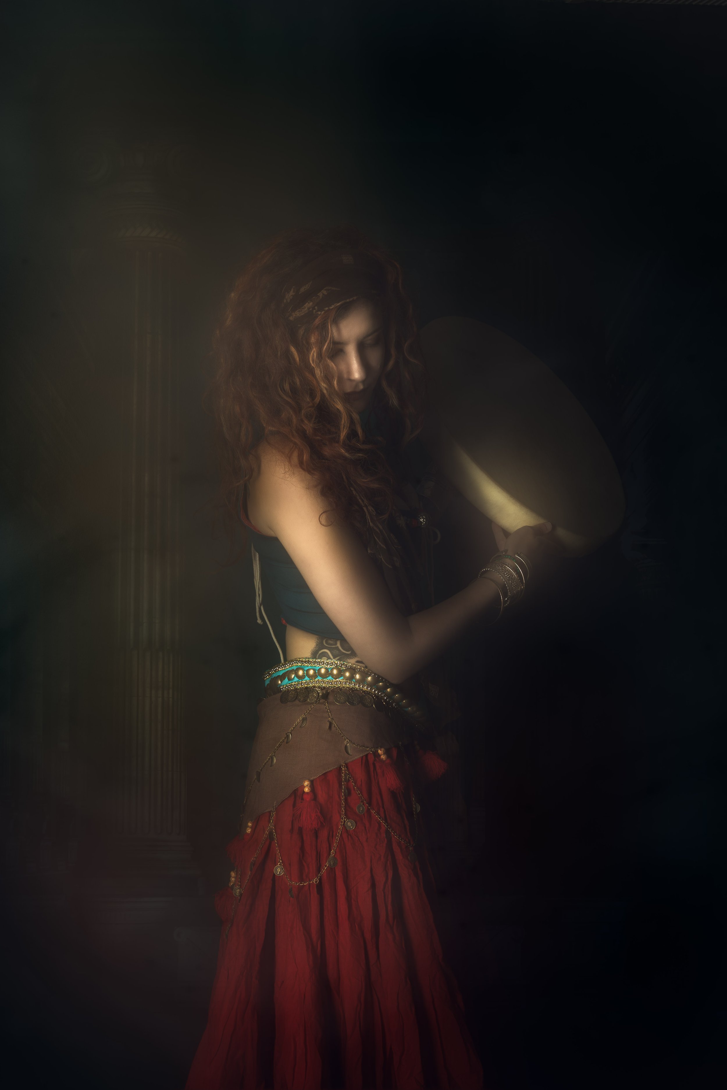 Photographie de portrait dramatique d’une femme en robe rouge. Univers cinématographique et émotion intense