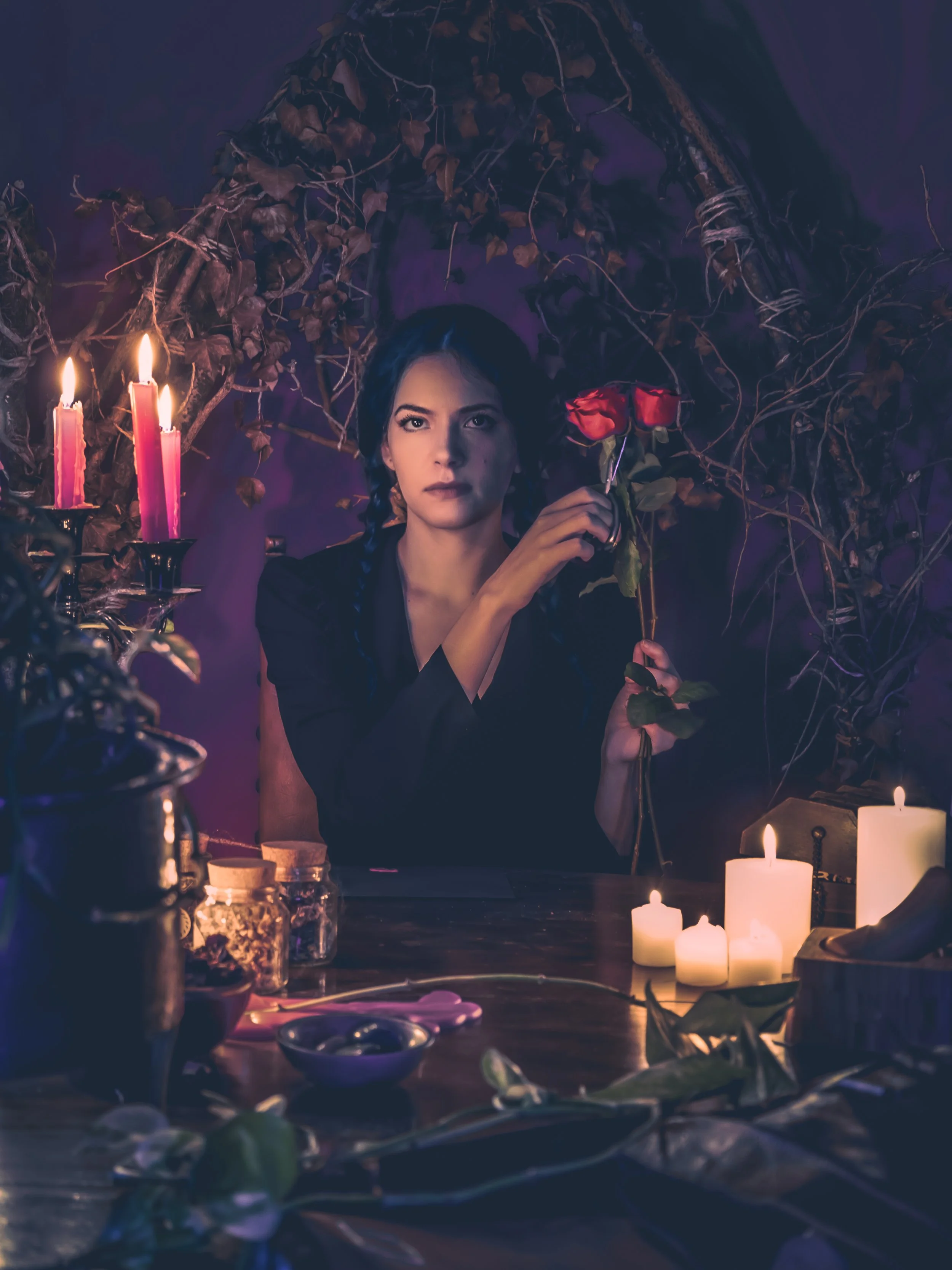 Mise en scène ésotérique avec cartes, bougies et tissus. Portrait mystique inspiré des rituels.