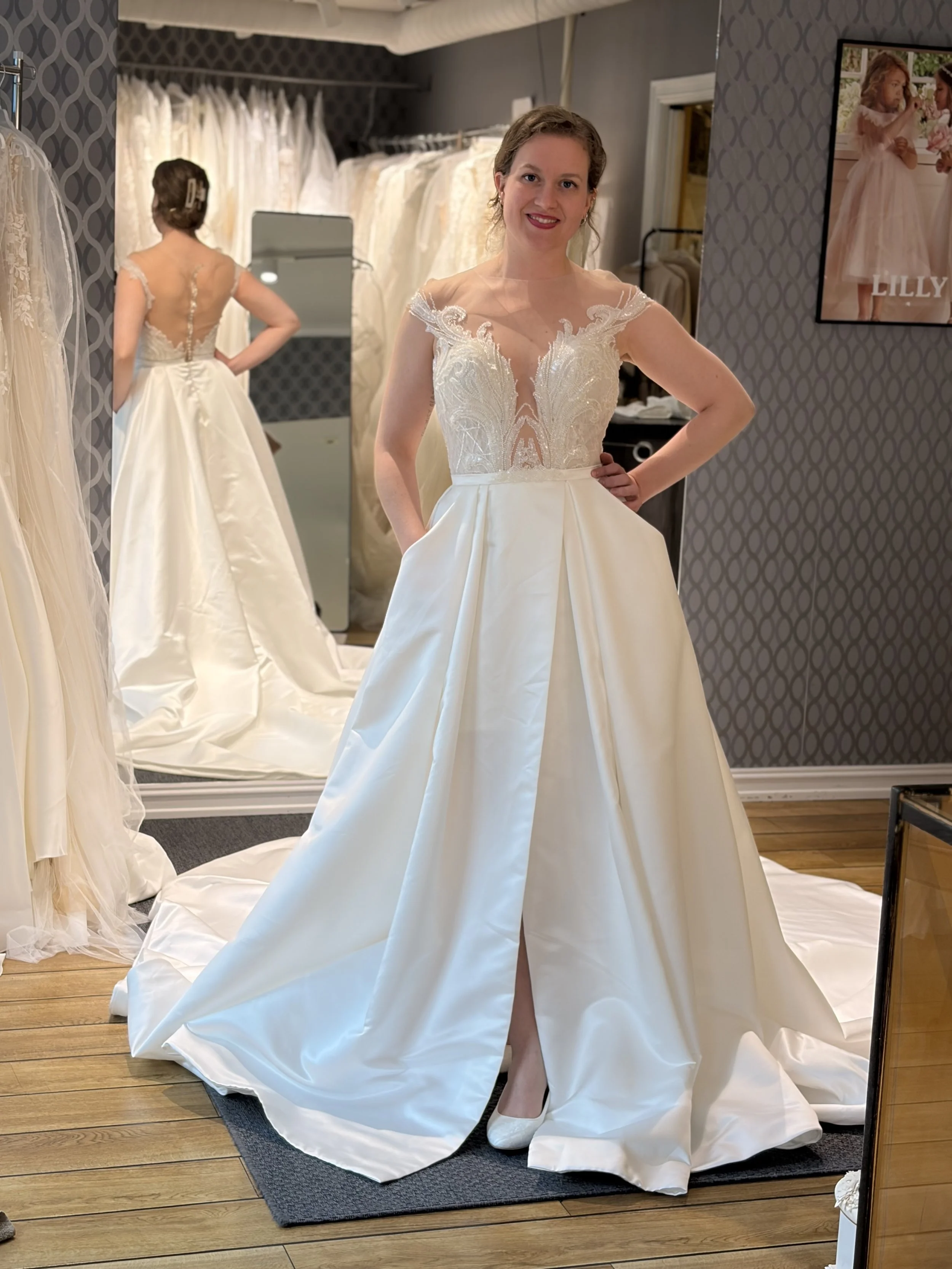 Lekker brudekjole med satengskjørt og glitrende topp. Brudekjolen har en vakker rygg, splitt, lommer og langt slep. Dette er en ubrukt brudekjole.