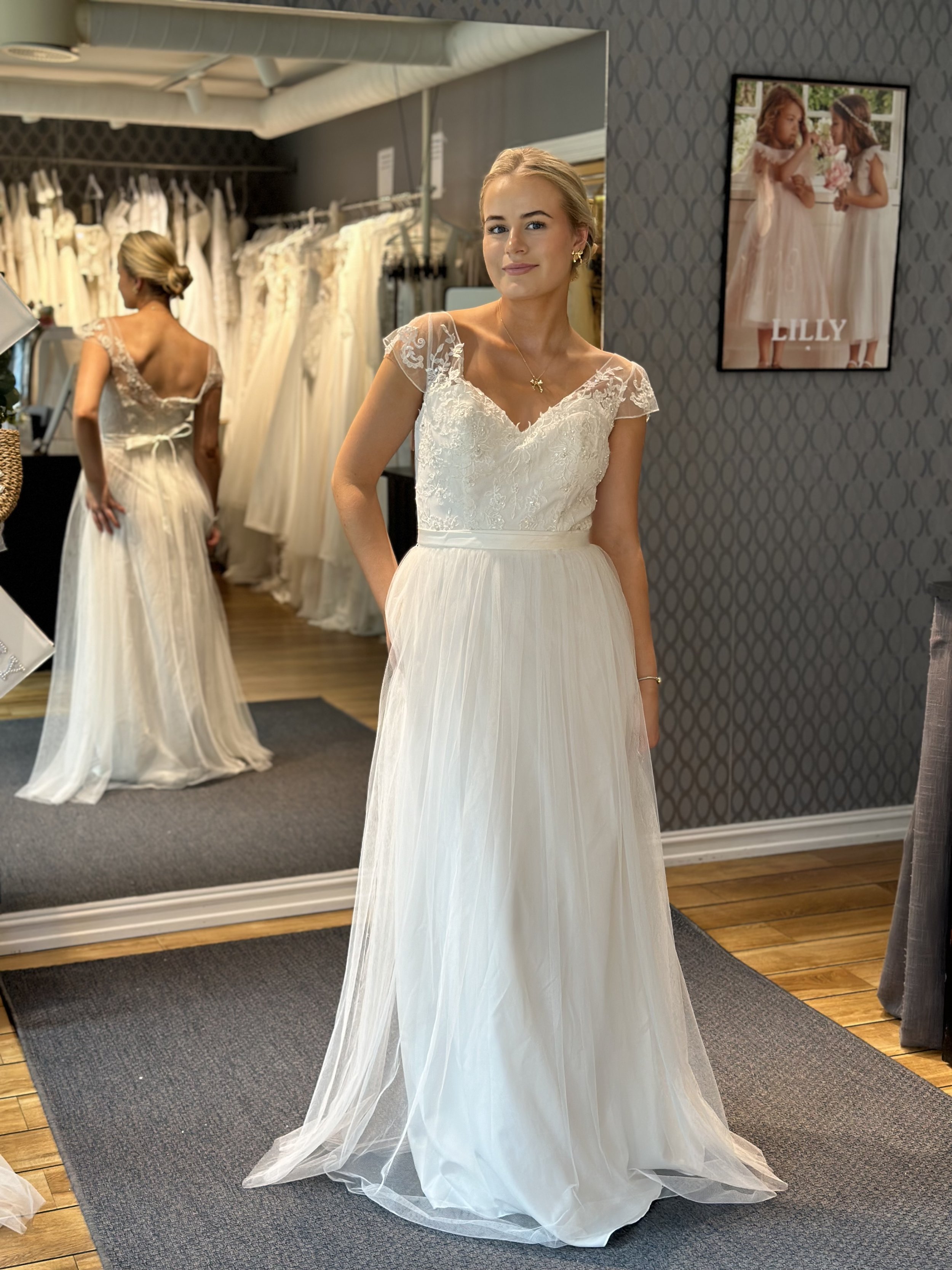 Lett og ledig fra Special day bridal wear. Denne har tyllskjørt og en liten arm. Overdelen har noen glitrende detaljer og skjørtet er av tyll. Belte som du kan knyte rundt livet. Brudekjolen har aldri blitt brukt.