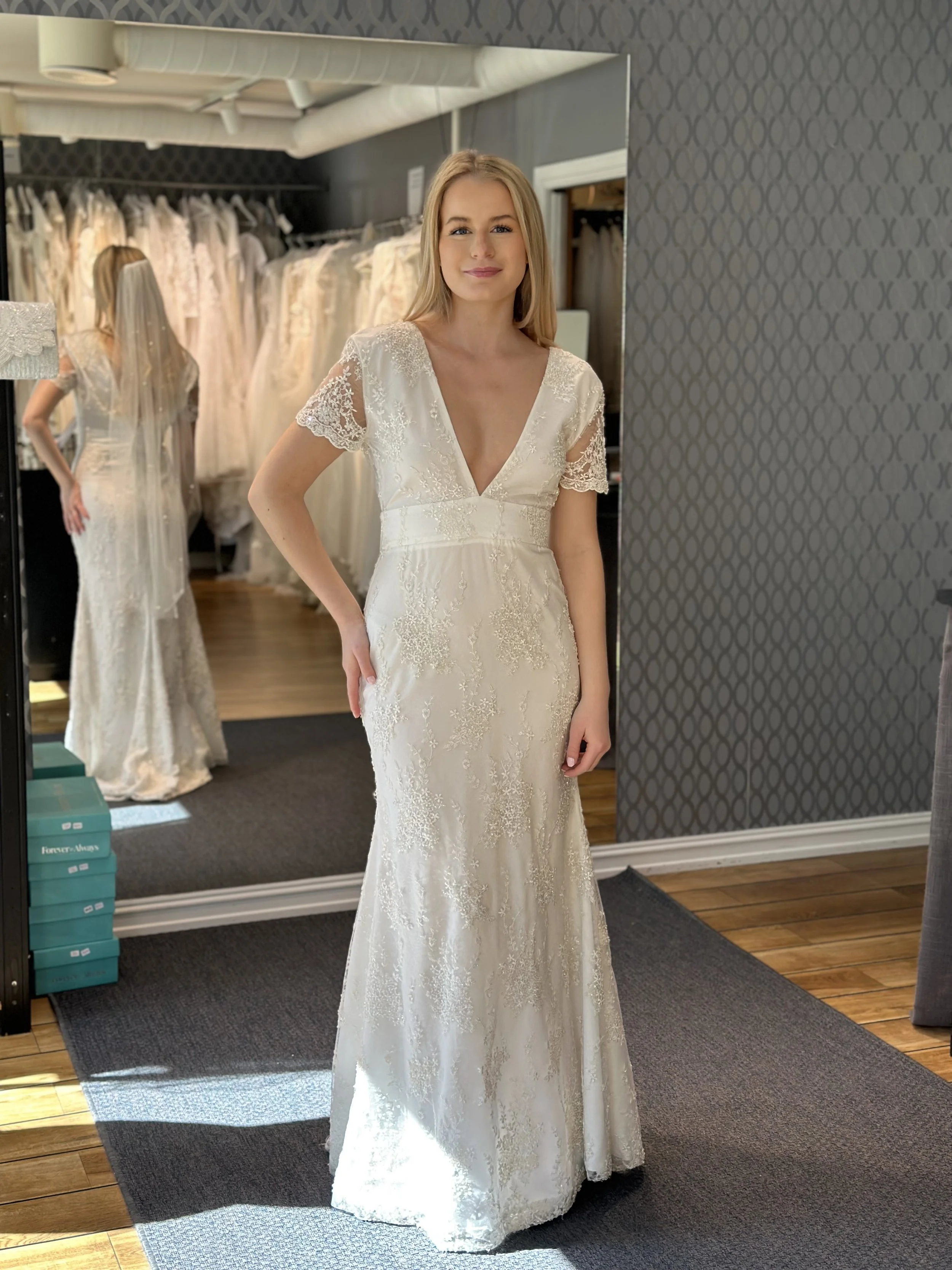 Maud, smal og ny brudekjole med glitrende stener. Dyp foran og dyp i ryggen. Denne er i str. 36. Du kan kjøpe den hjem til en god pris i nettbutikken vår.