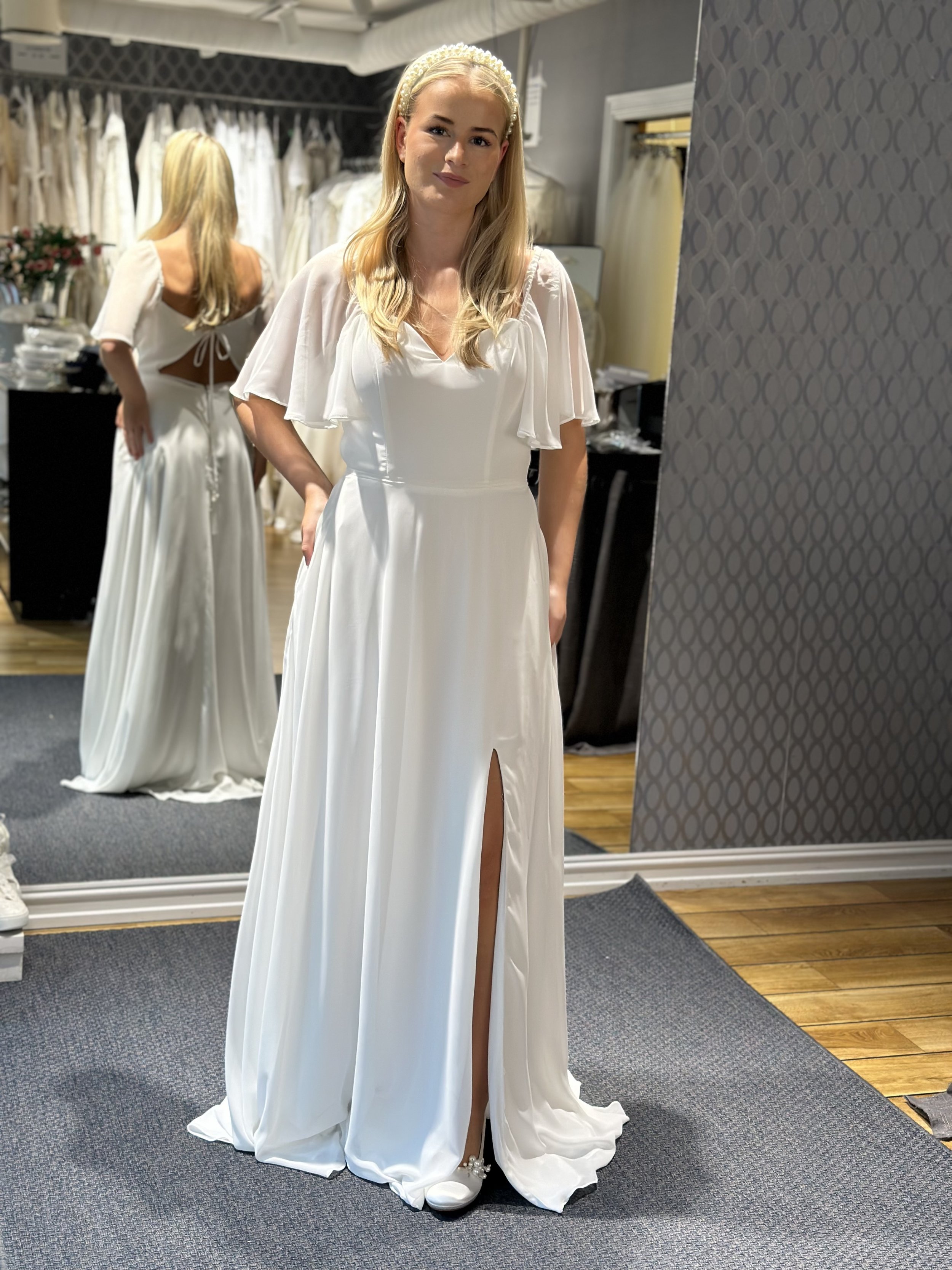 Off shoulder, åpen rygg, splitt og lommer! Rene kinderegget av en brudekjole. Fin pris har den også og den er aldri brukt.