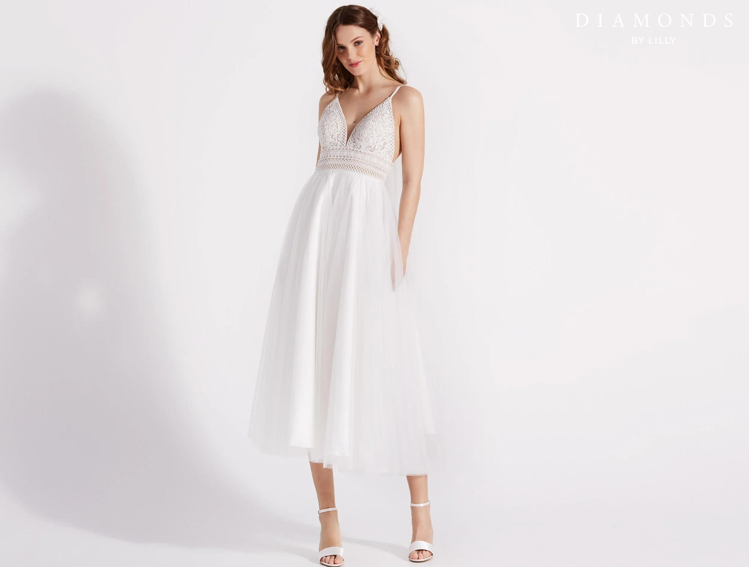 Søt kort brudekjole med tynne stropper. Den har blonde overdel og tyllskjørt, og åpen rygg. Dette er en av våre nye brudekjoler, og den er fra Lilly