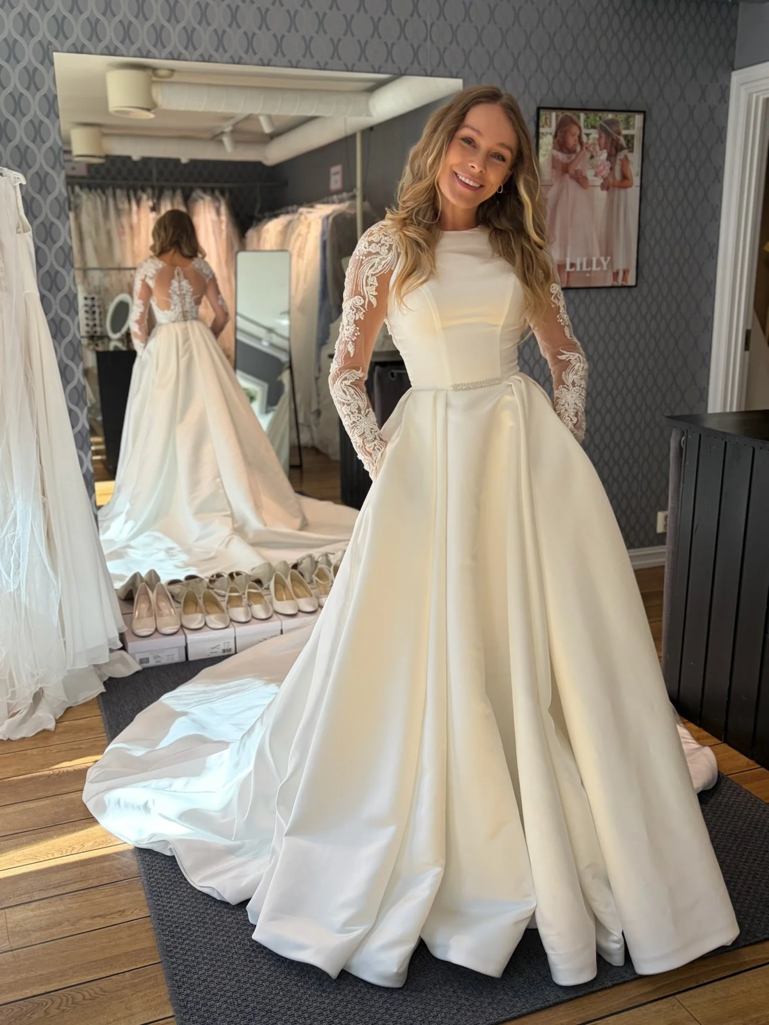 Nydelig ny brudekjole i sateng med lommer, blondeermer og smalt brudebelte fra Monreal Bridal, "Bella" - størrelse 34. 