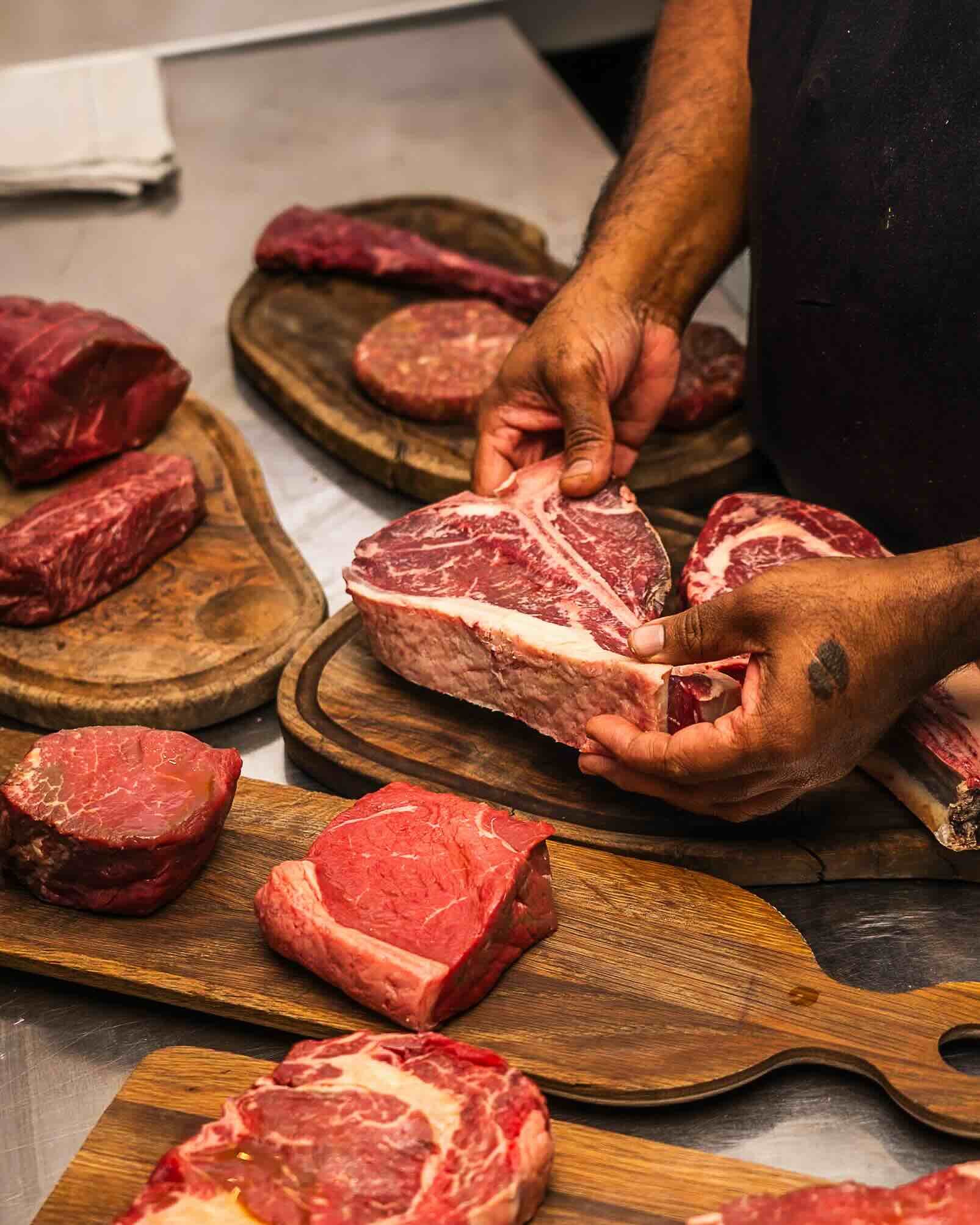 Spread of steak cuts with one being held