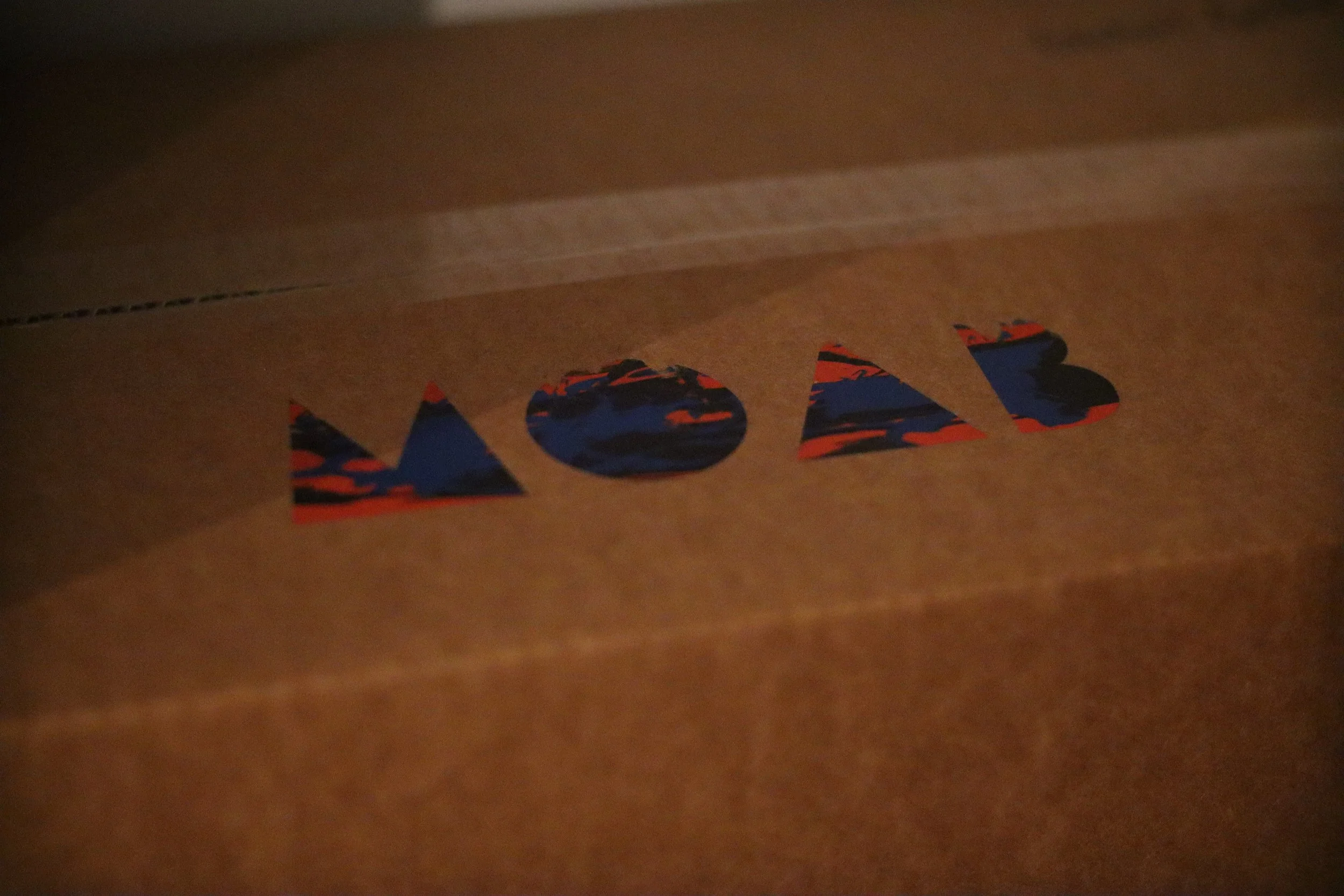 Branded cardboard packaging featuring the MOAB logo in a multicolored design, showcasing custom packaging solutions for businesses in Texas.