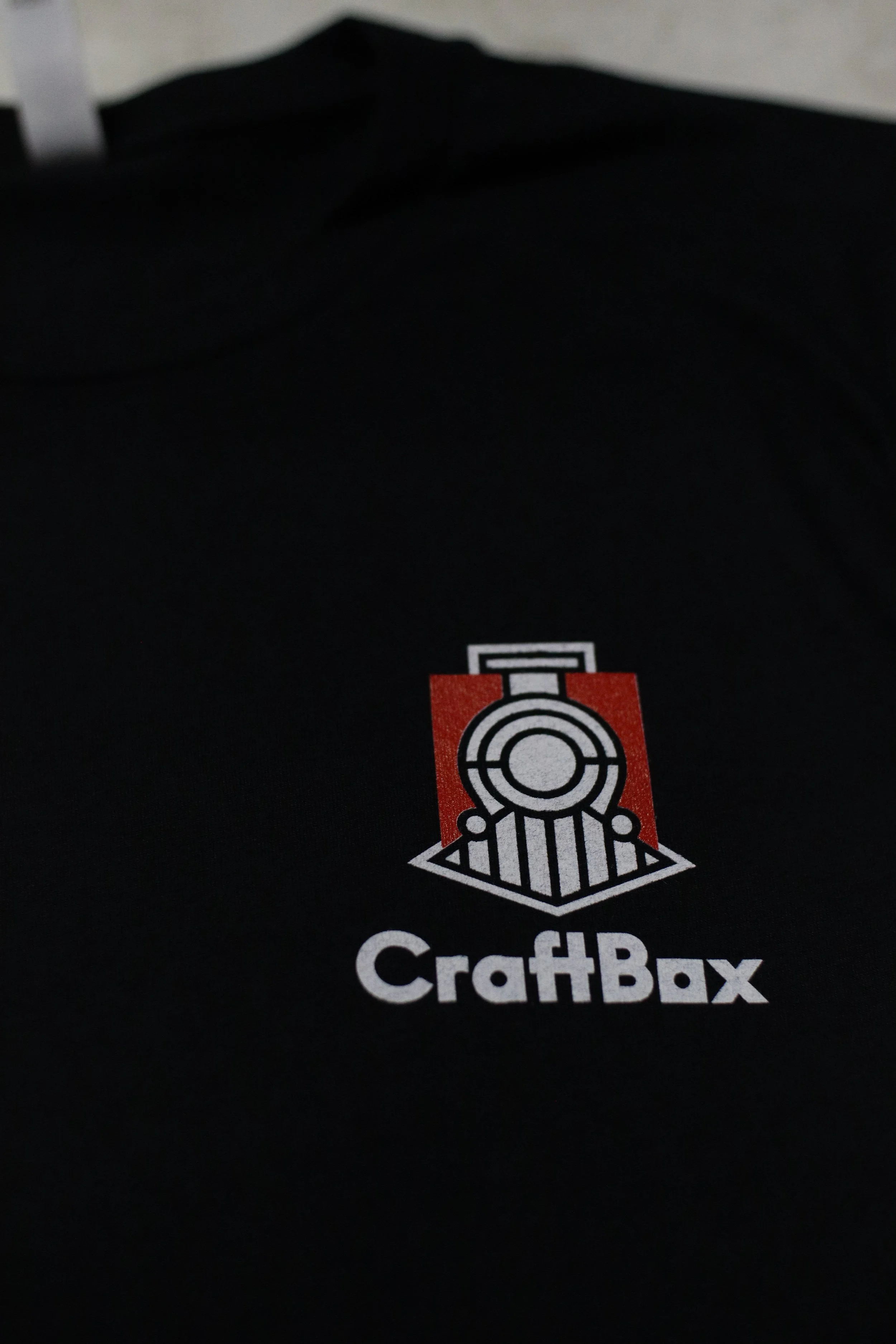 Close-up of a CraftBax logo on a black surface with a target icon above the text.