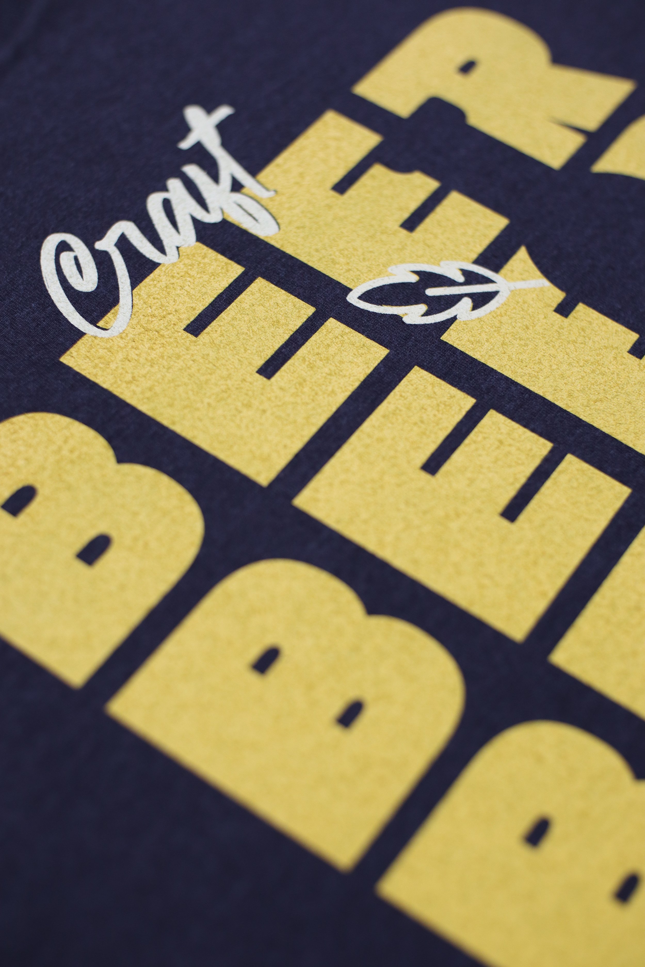 Close-up of a yellow graphic design with the word 'Thank' written in cursive and a stylized leaf illustration, on a dark background.