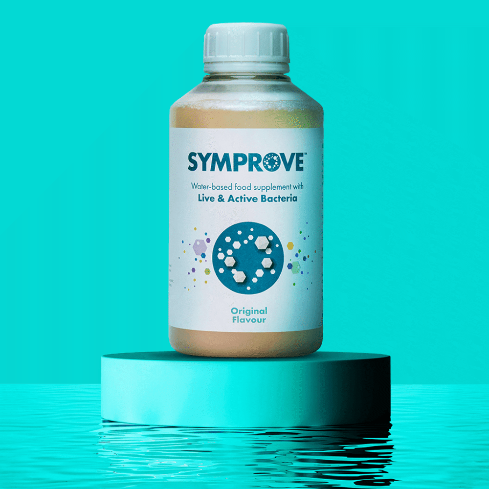 A bottle of Symprove water-based food supplement with live and active bacteria, placed on a blue pedestal against a blue background.