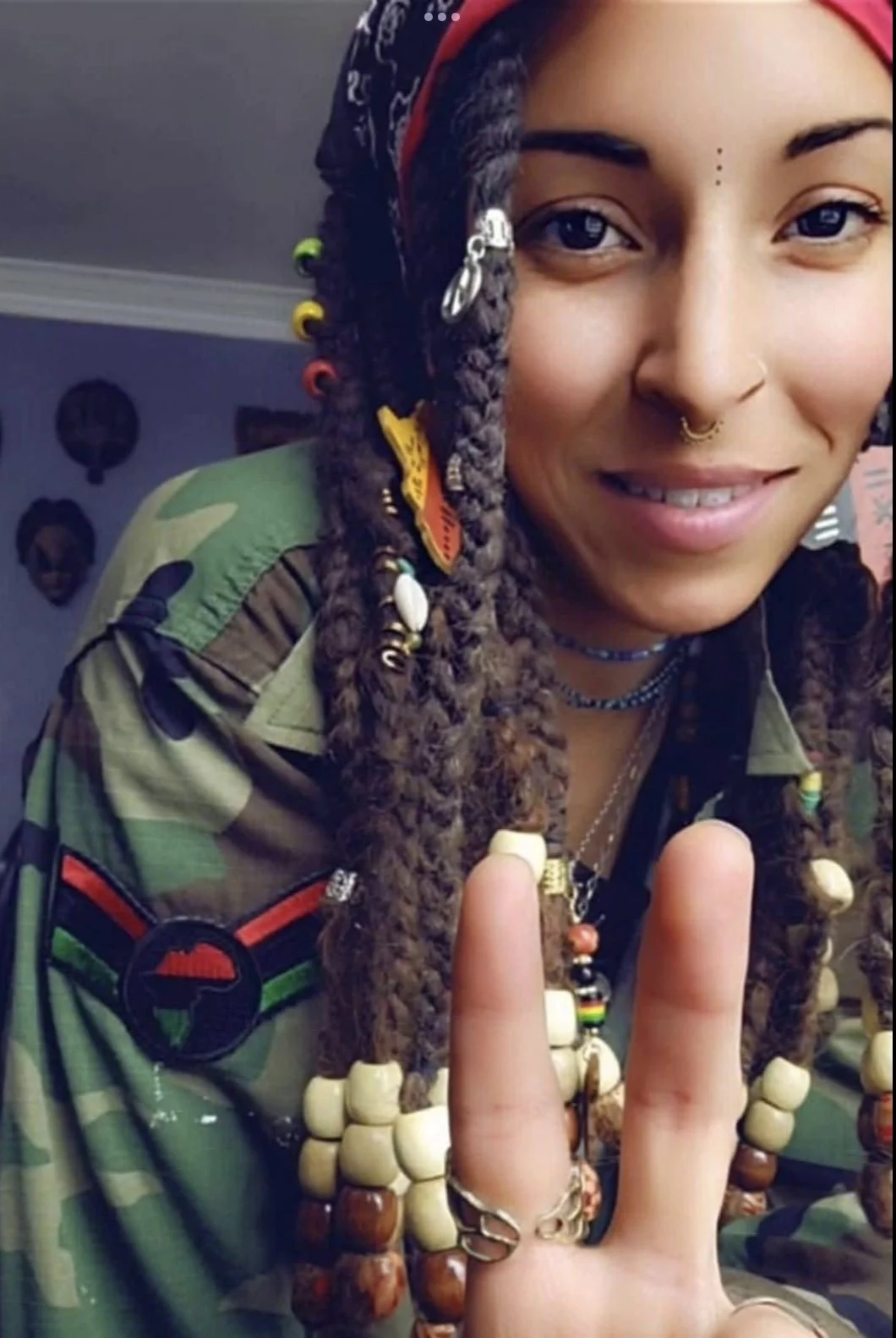 woman with long braids gives a peace sign