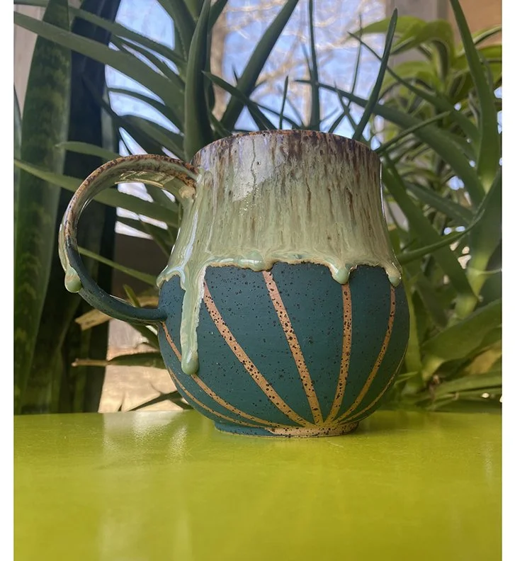 artisan ceramic mug with running glaze and stripes on the bottom