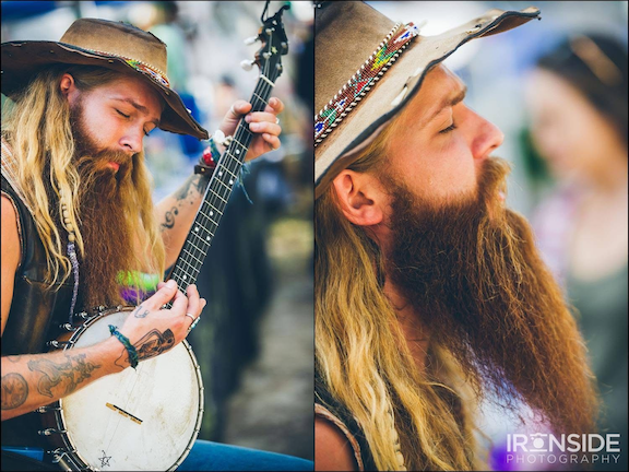 man with beard and hat singing into microphone