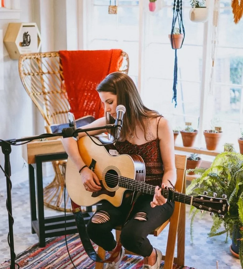 woman playing guitar on a porch