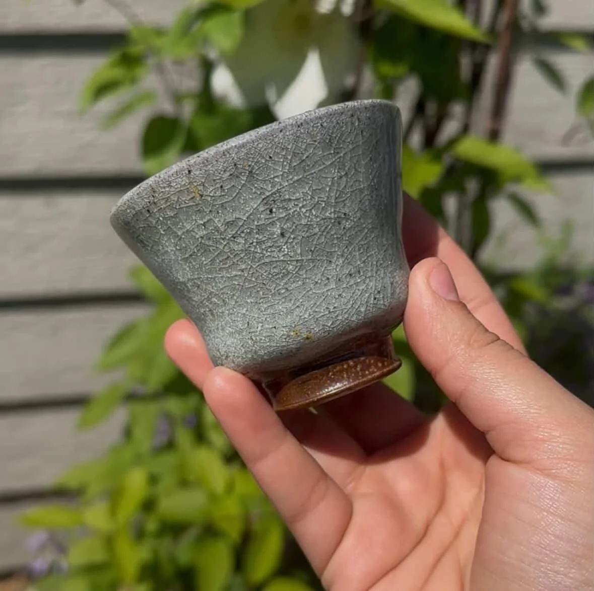 Small gray ceramic cup in hand