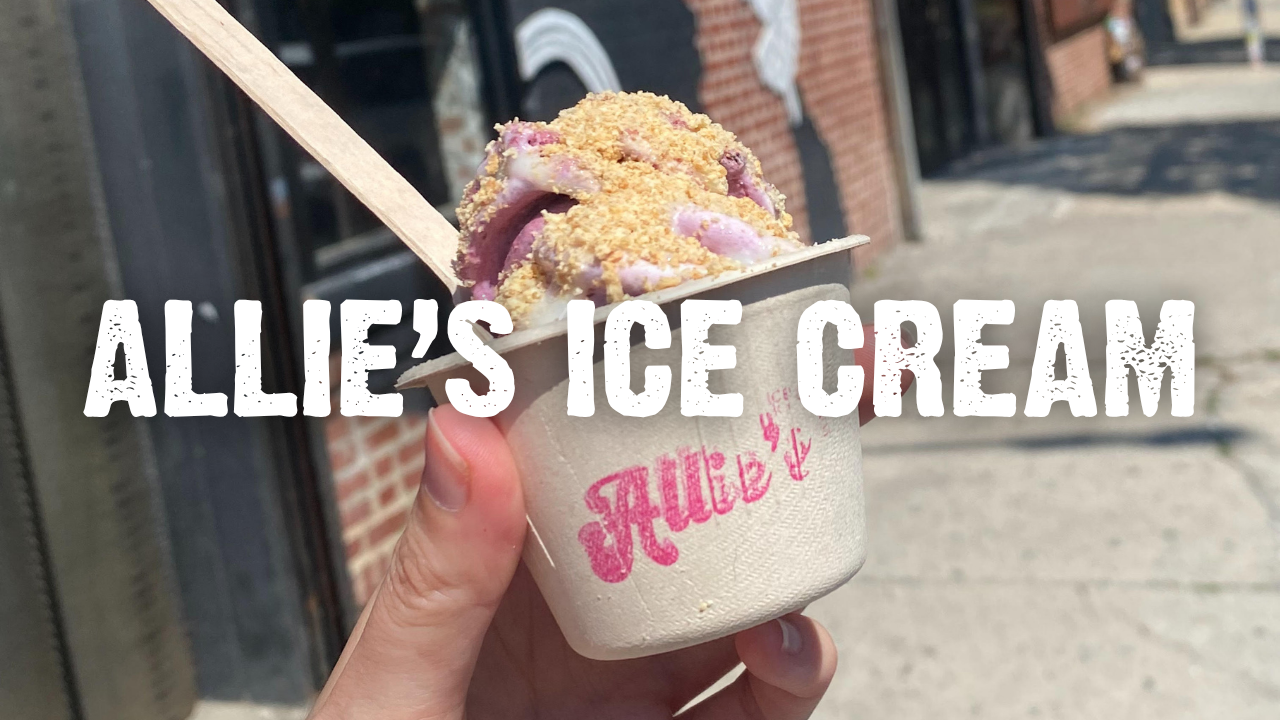 A hand holding a cup of ice cream blended with fruit