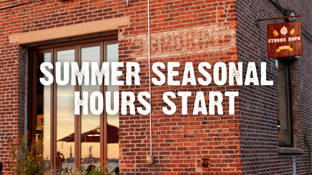 Summer Seasonal Hours Start with exterior of taproom with brick wall and sunset reflecting off windows