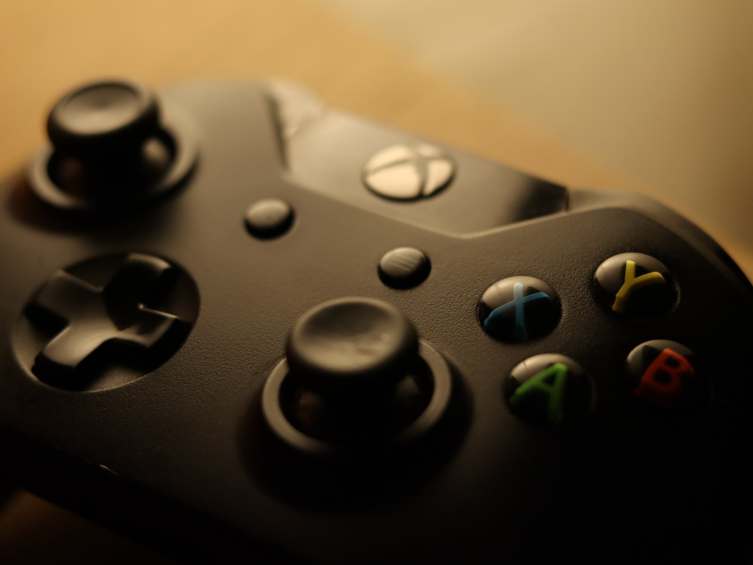 Close-up of a black Xbox controller with visible buttons and joystick.