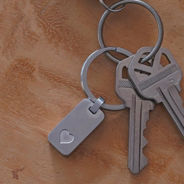 Pewter keychain with heart-shaped design, suitable for personalization and attaching to keys or bags.