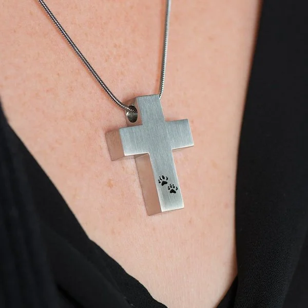 Pewter cross pendant with black paw prints, matching 19-inch chain, and discreet memento compartment.