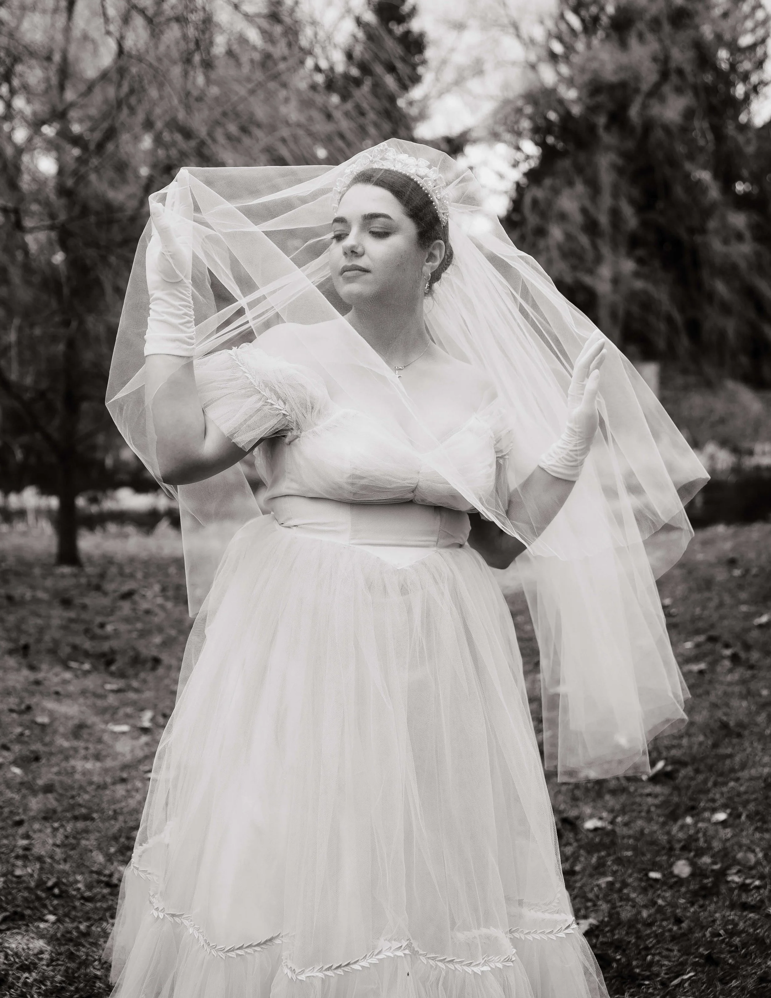 En noir et blanc, une marié pose sous son voile.