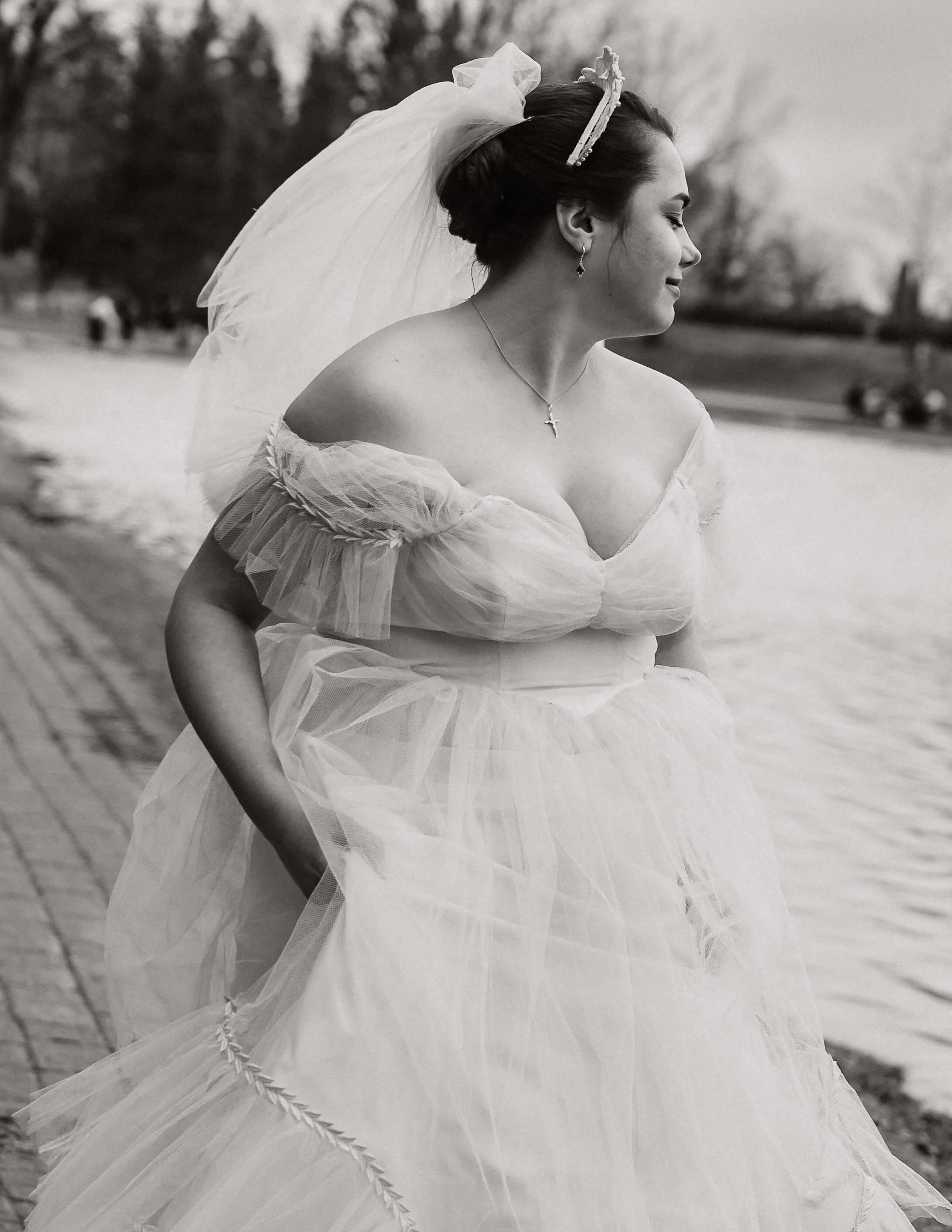 Une femme en robe de marié cours en tenant sa robe dans ses main.