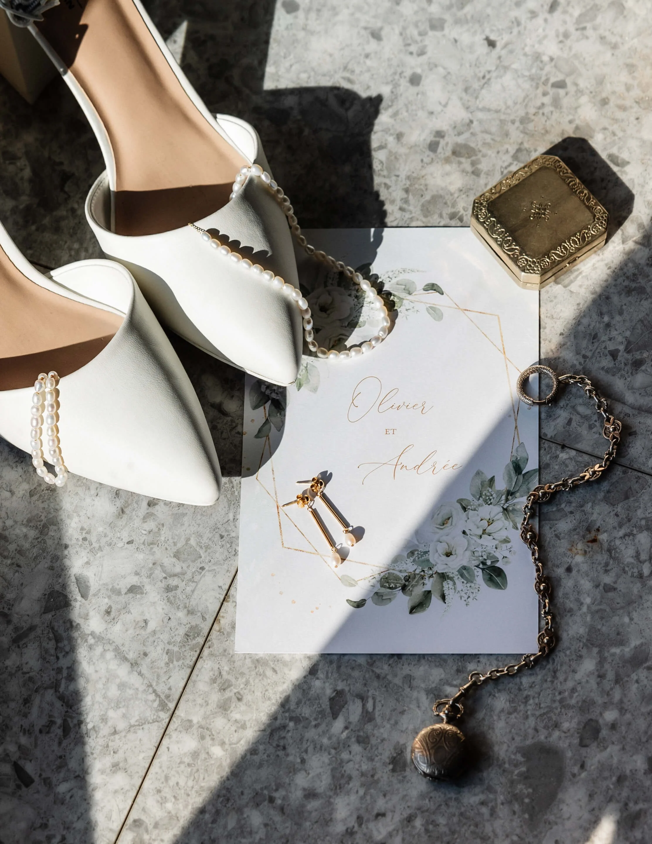Détails d'un pamphlet de mariage, des talons hauts blancs, des boucles d’oreilles et bijoux.