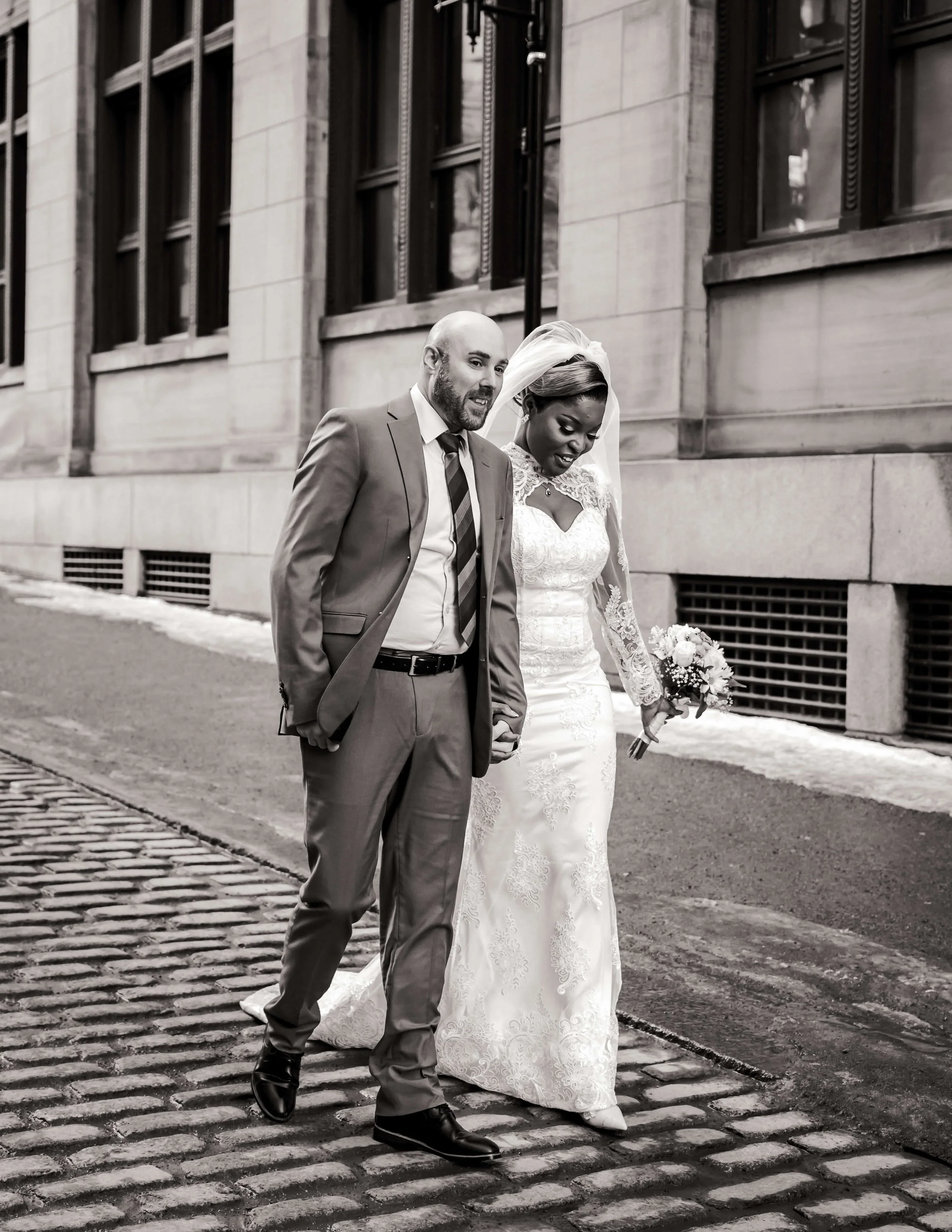 Un homme et une femme en habit de mariés se promènent dans les rues du Vieux-Montréal.