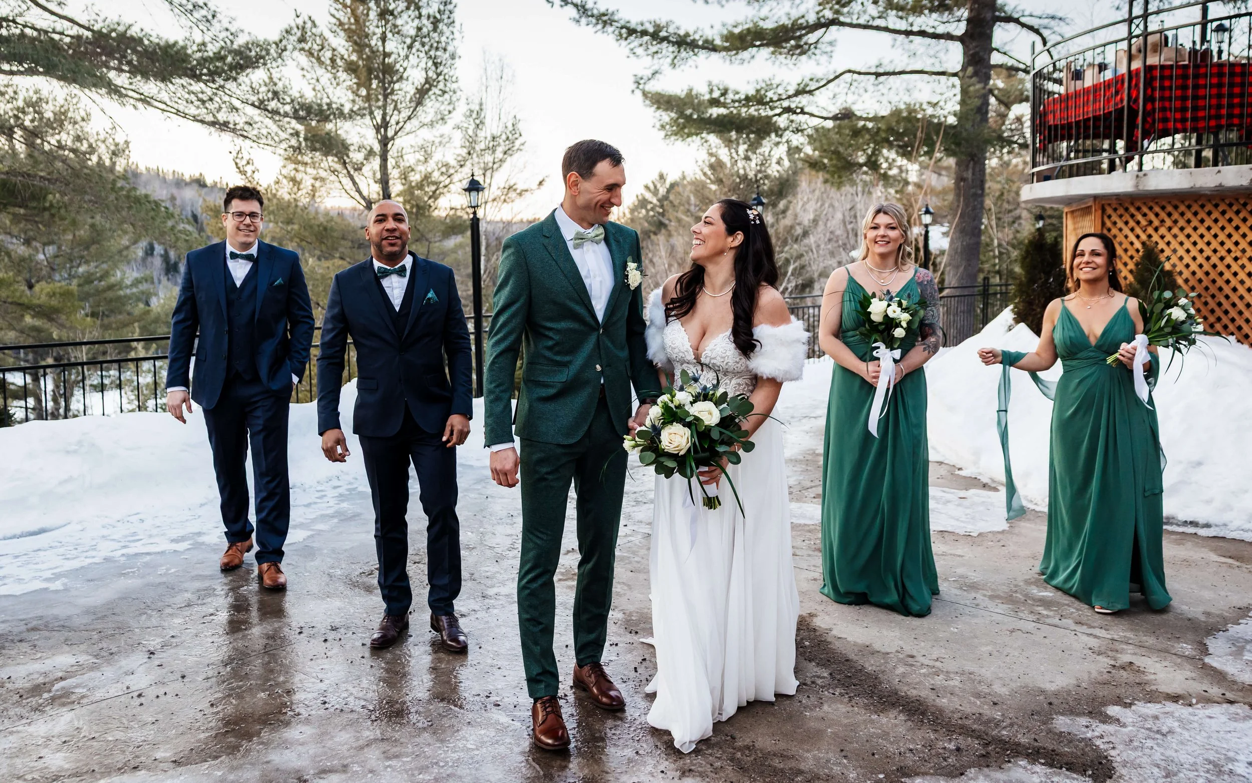 Un cortège de mariage et les nouveaux mariés marchent sur une terasse.