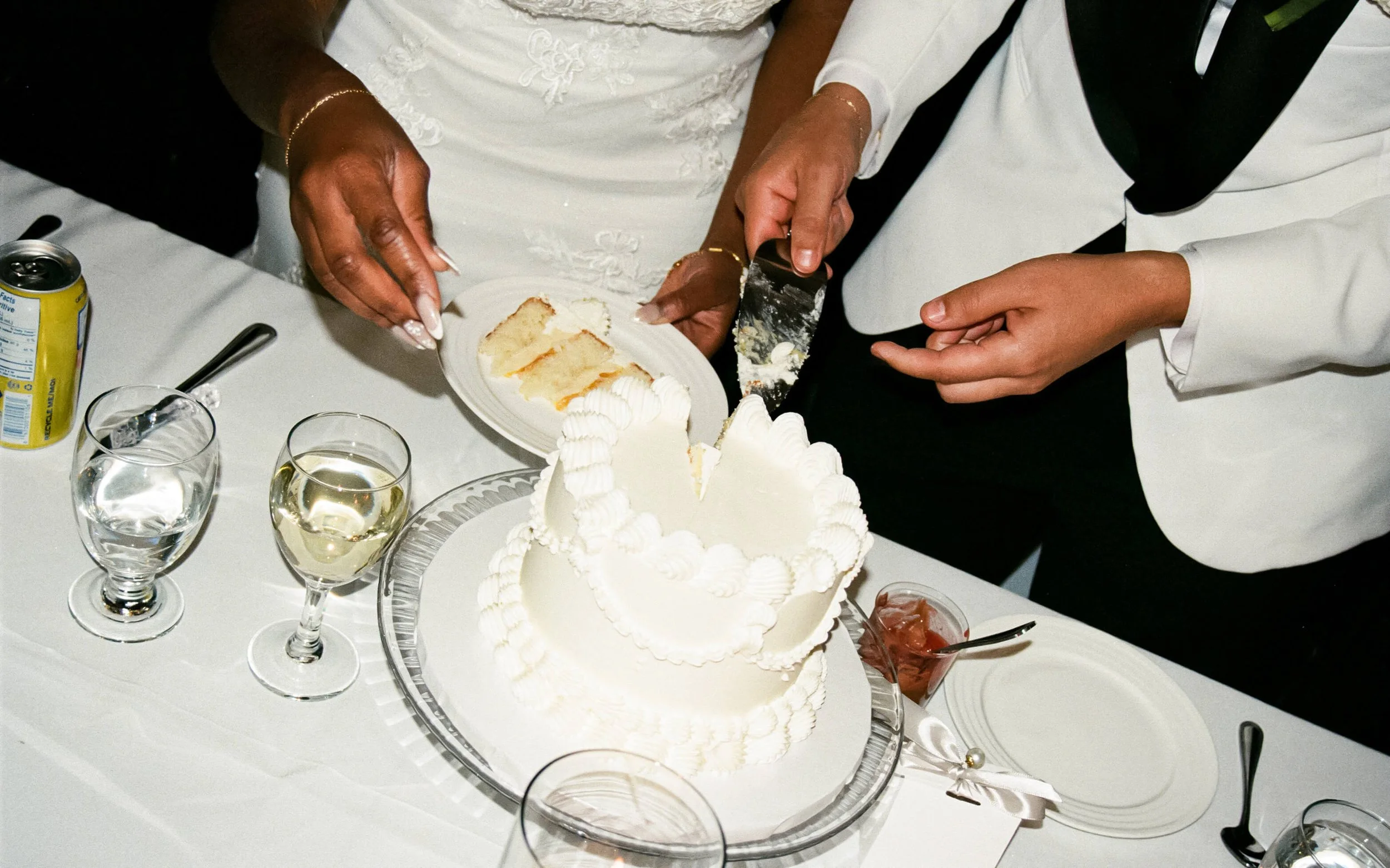 Photographie argentique de mariés qui coupe leur gâteau