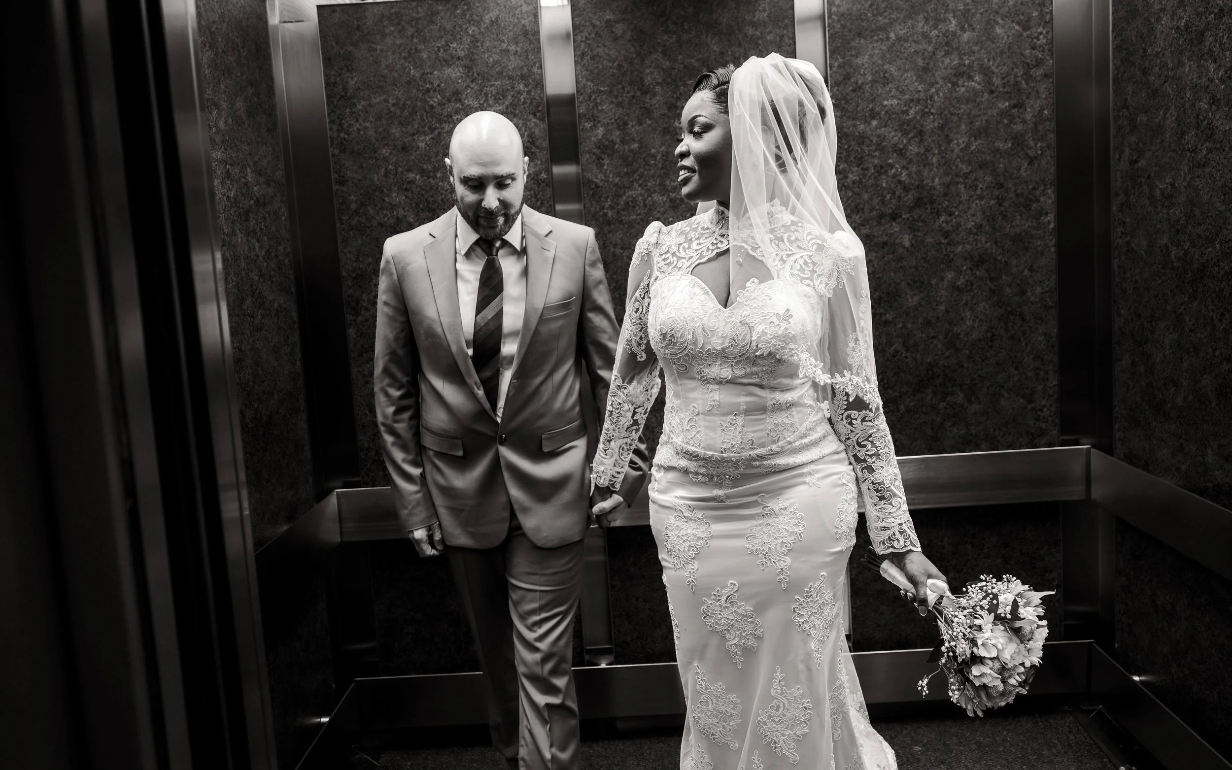 Un homme et une femme en habit de mariés sont dans un ascenseur au palais de justice de Montréal.