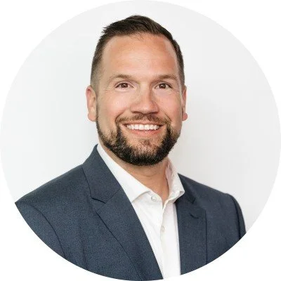 Headshot of Dan Cogswell, Head of Leadership Development at Leadr, smiling in professional attire against a clean, neutral background.